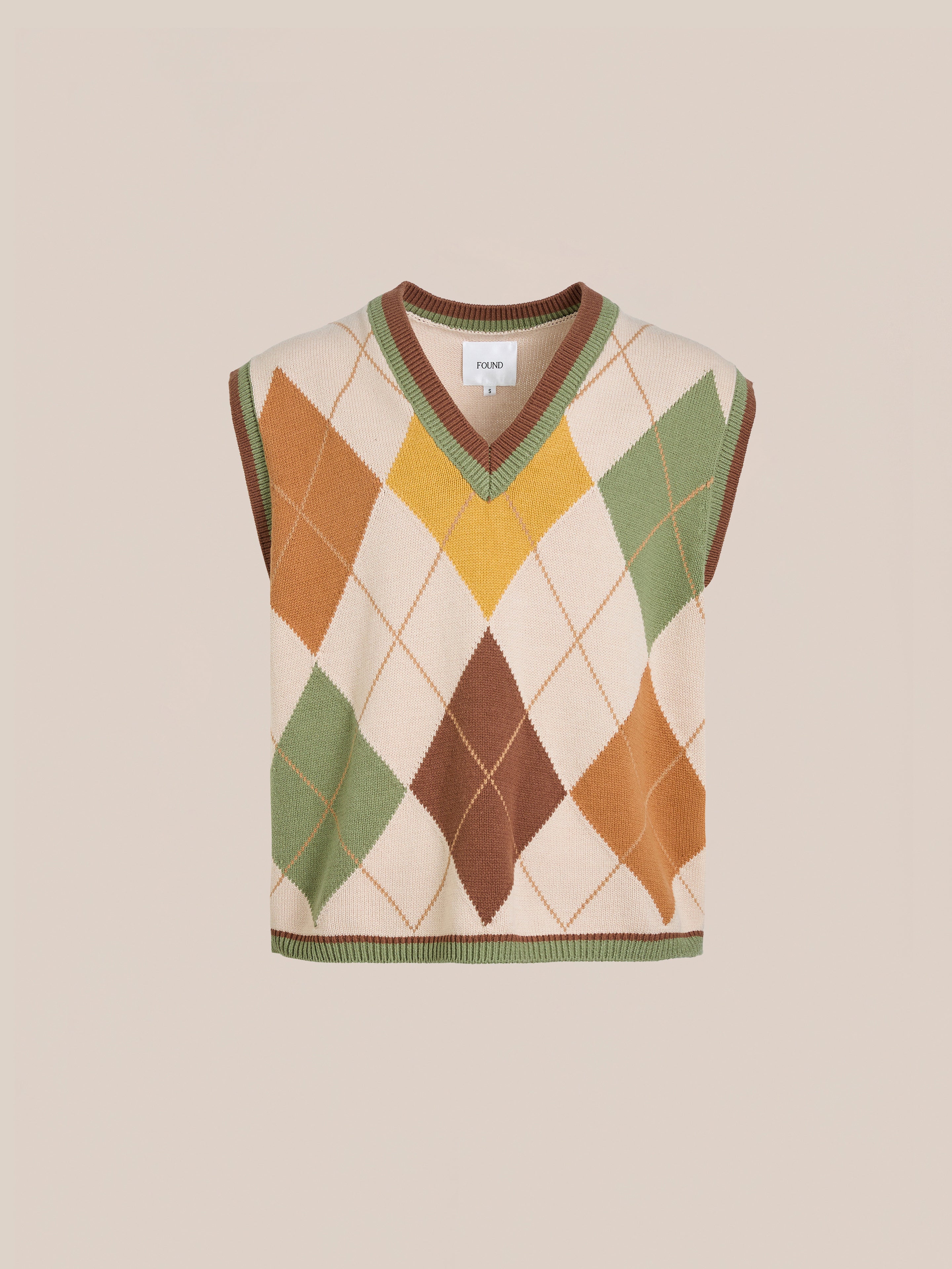 The FOUND Argyle Knit Vest boasts a vintage-inspired diamond pattern in beige, orange, green, and yellow. Its unisex relaxed fit makes it a versatile wardrobe addition.