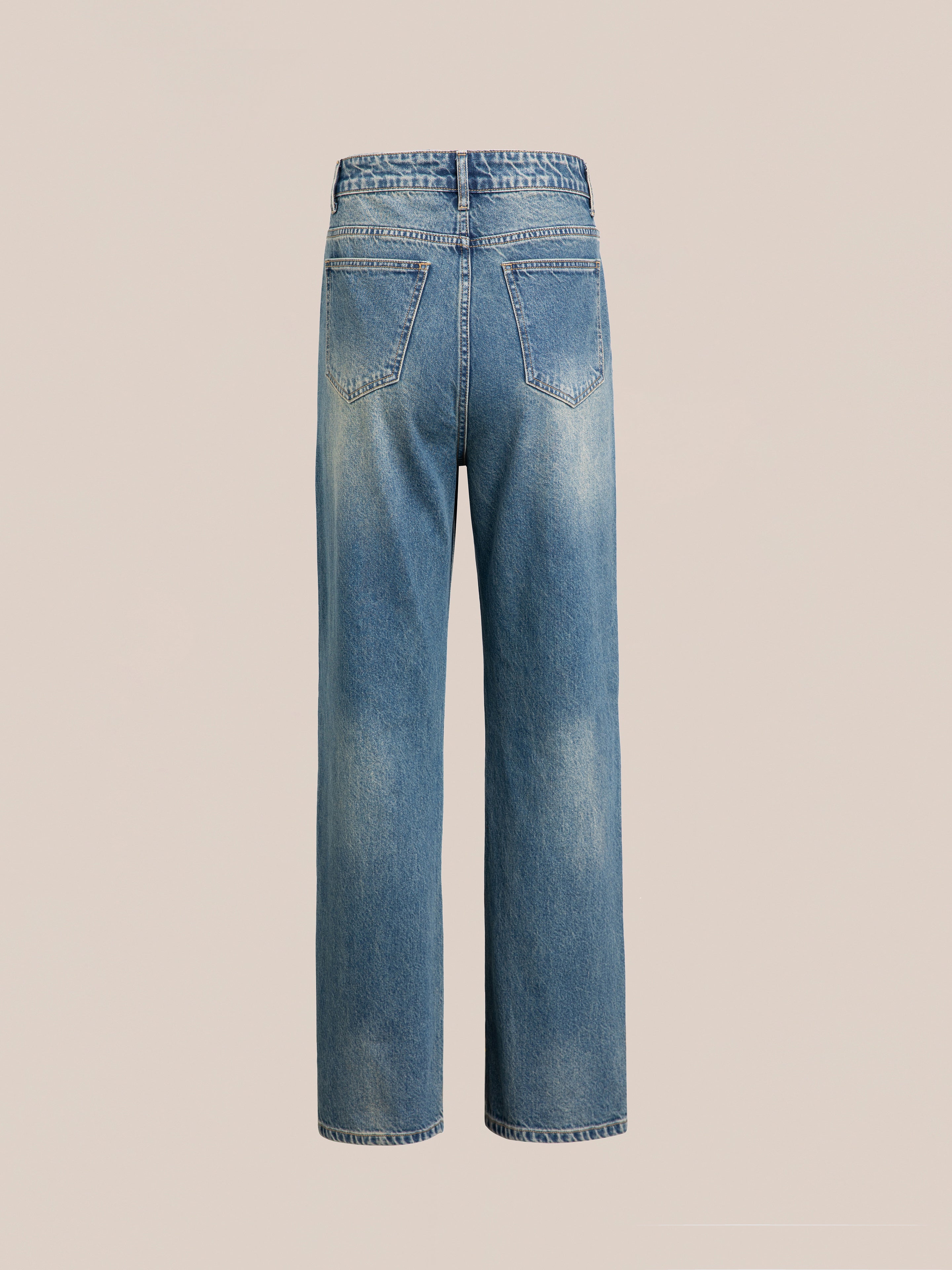 A pair of FOUND's Azar Studded Jeans shown from the back, featuring two rear pockets, a vintage blue wash, and antique matte silver studs.