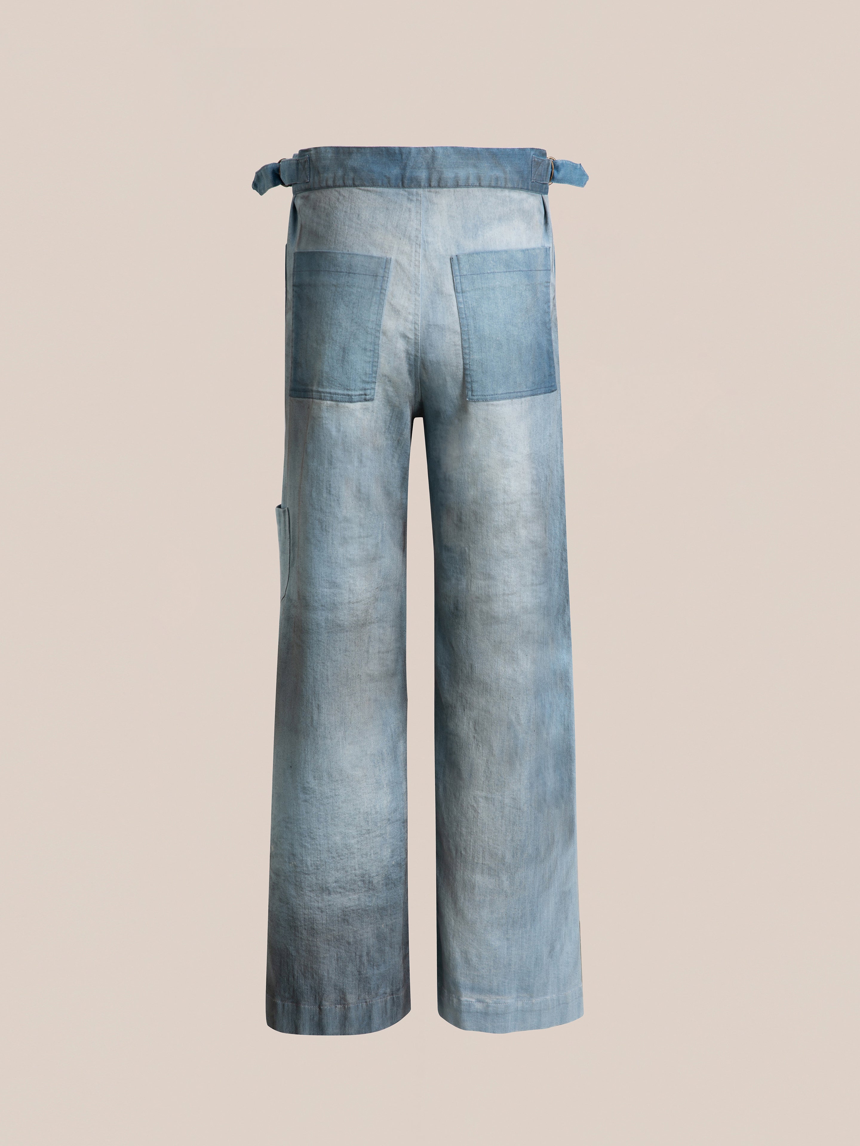 Back view of the Multi Patch Painters Work Pants by FOUND, featuring light-washed, wide-legged denim with two back pockets, a belted waist, and a classic slouchy fit reminiscent of antique French painter uniforms.