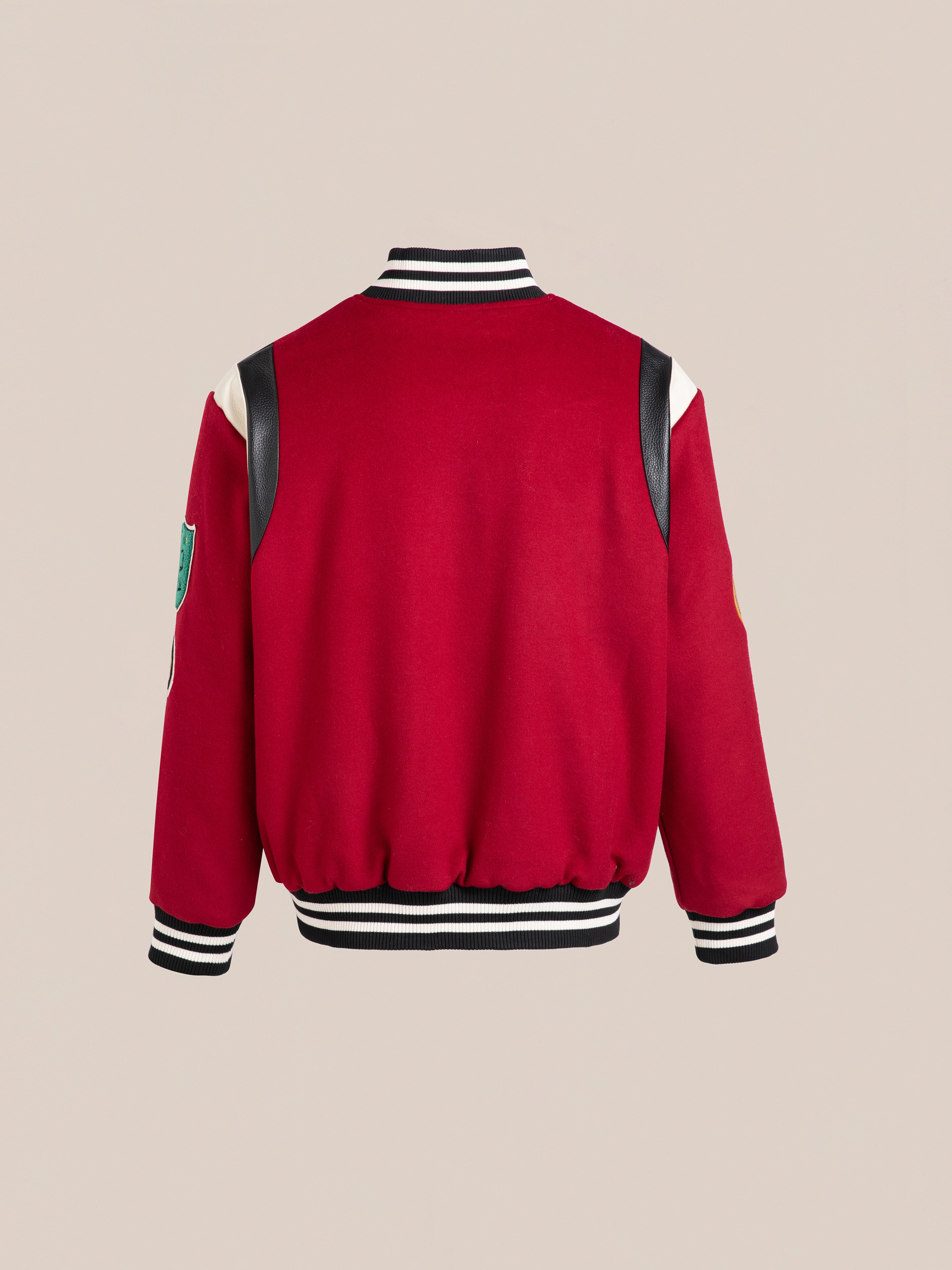 FOUND's unisex Letterman Varsity Jacket features a red body, black and white striped cuffs and collar, black shoulder patches, chenille chest logo, and a left sleeve crest displayed against a plain background.