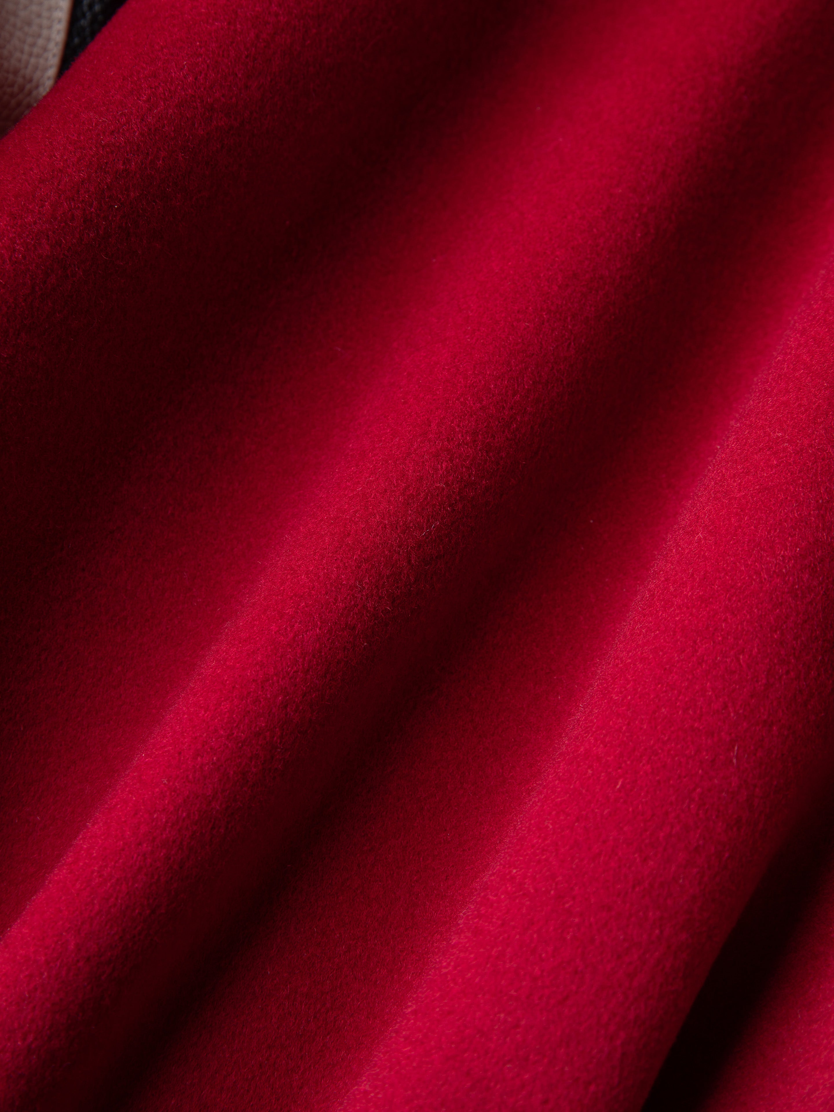 Close-up of red velvet fabric with soft folds and smooth texture, reminiscent of the luxury you'd expect lining a FOUND Letterman Varsity Jacket.