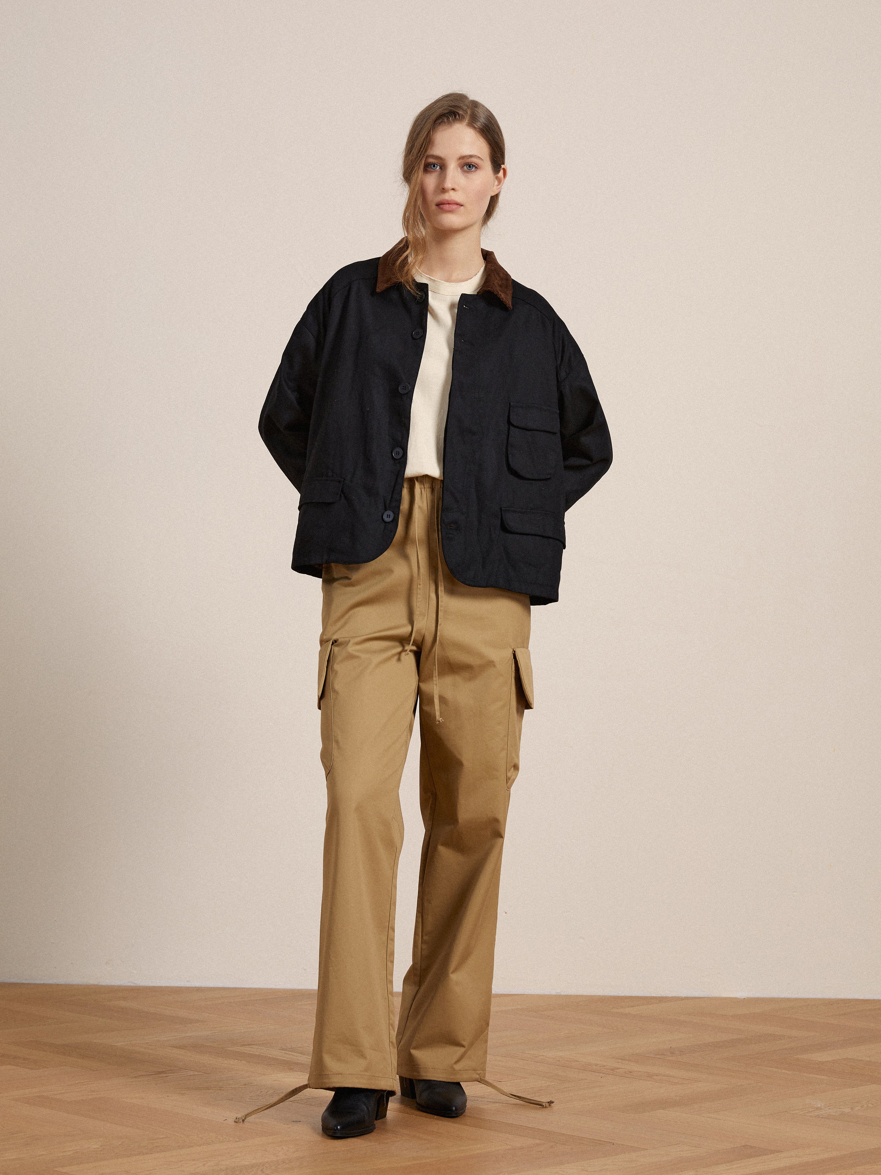 A woman wearing a khaki cargo jacket and tan Found Twill Cargo Drawstring Pants.