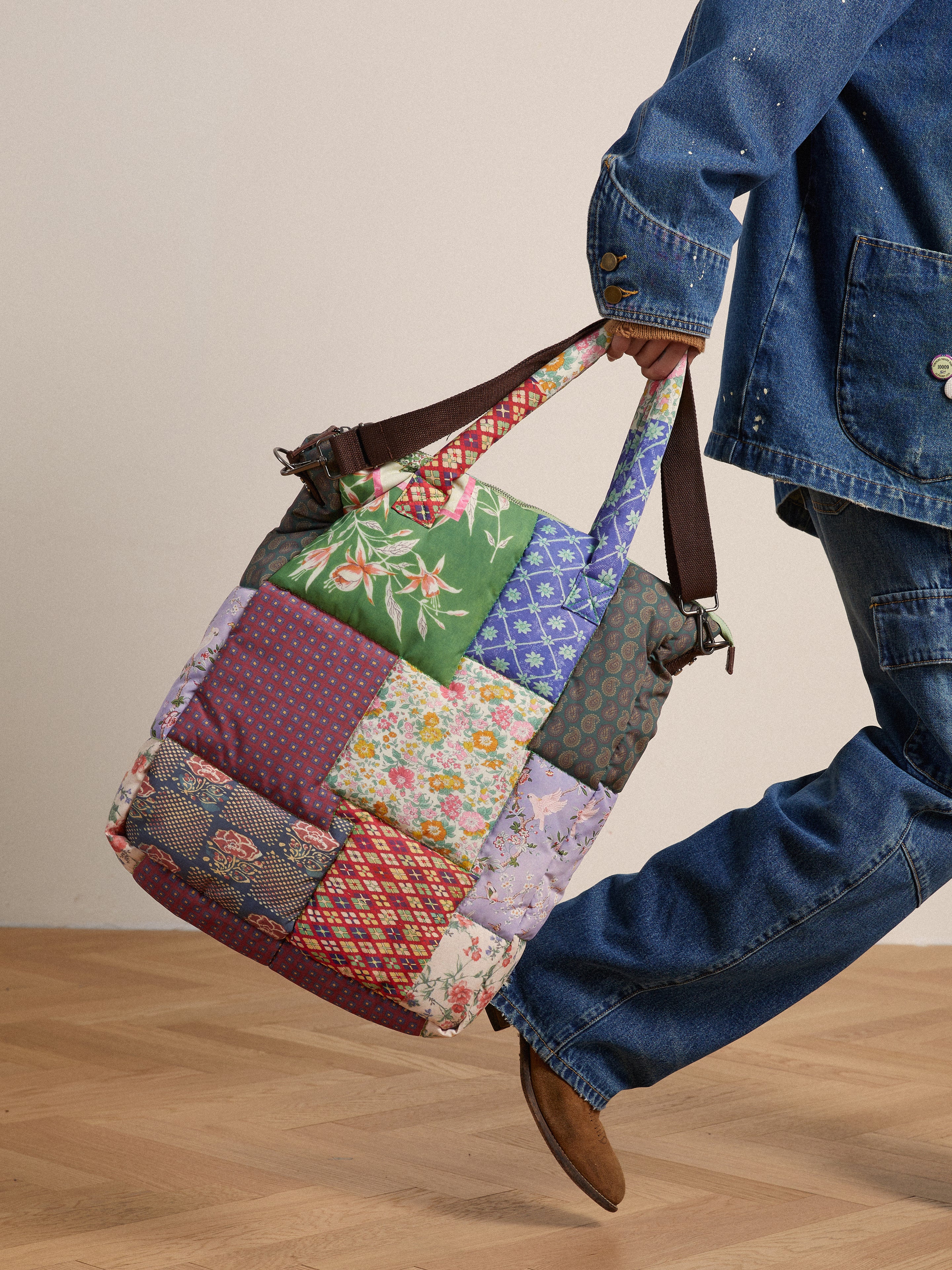 A man carrying a Gardenia Tapestry Bag adorned with South Asian prints from Profound.