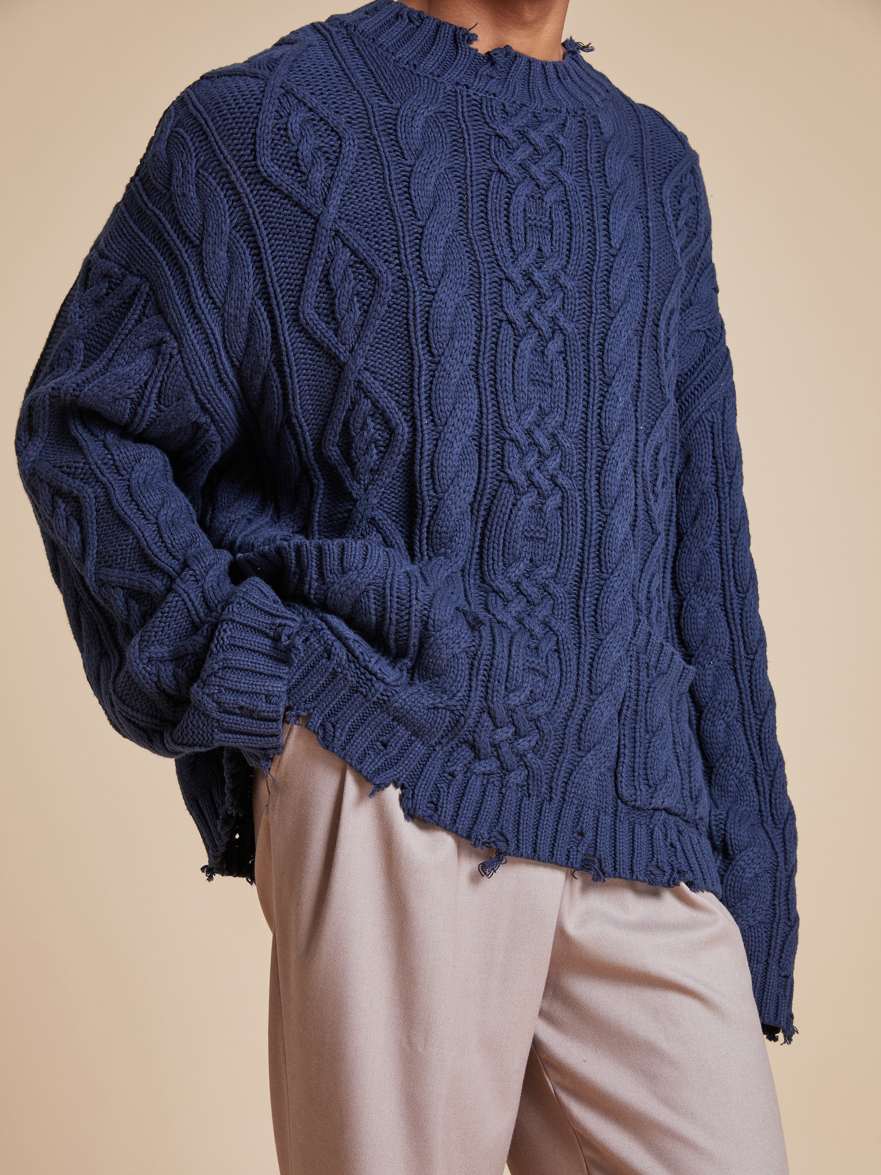 The model is wearing a Found Astral Distressed Cable Knit sweater.