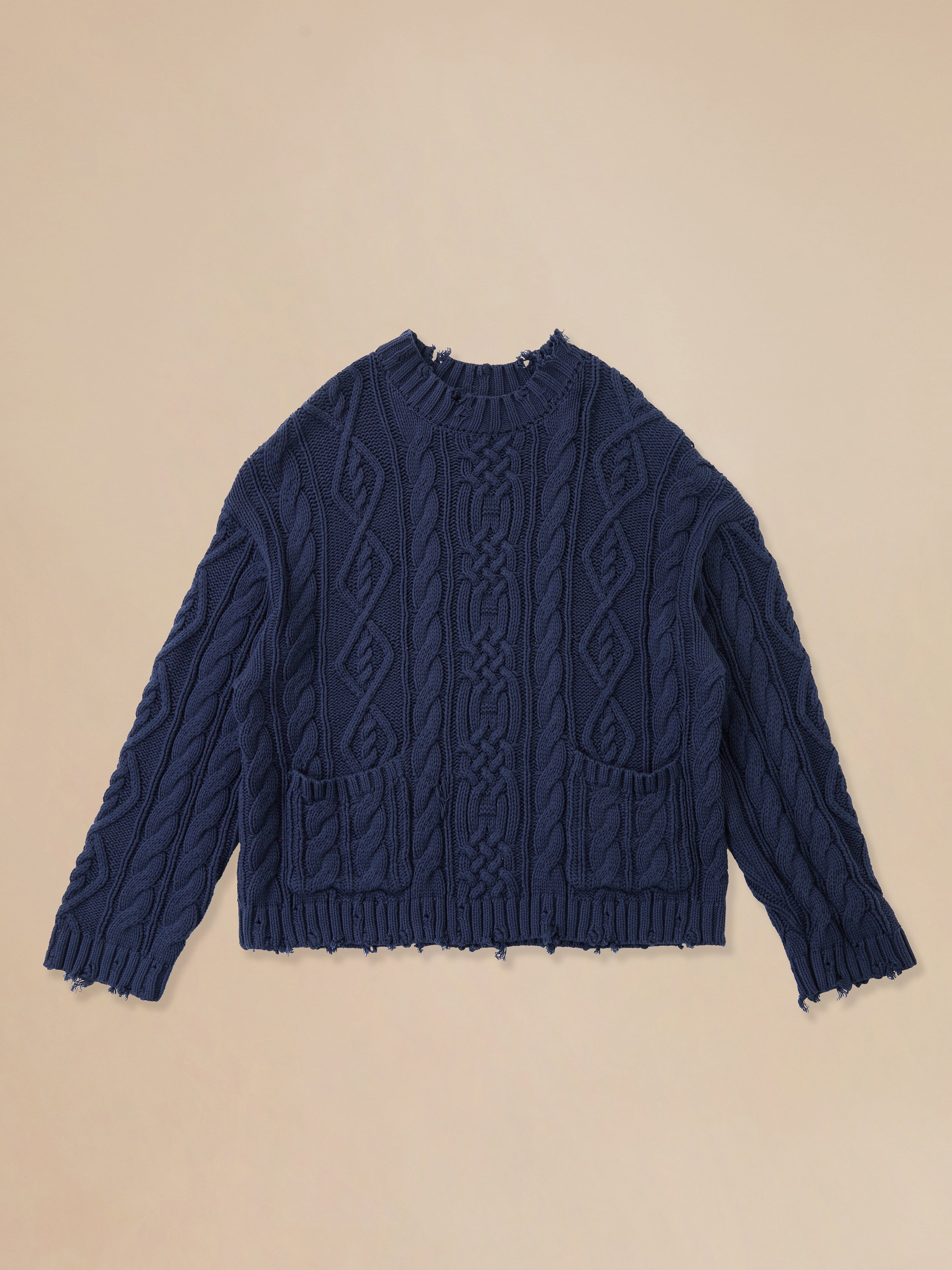 Found Astral Distressed Cable Knit Sweater on a beige background.