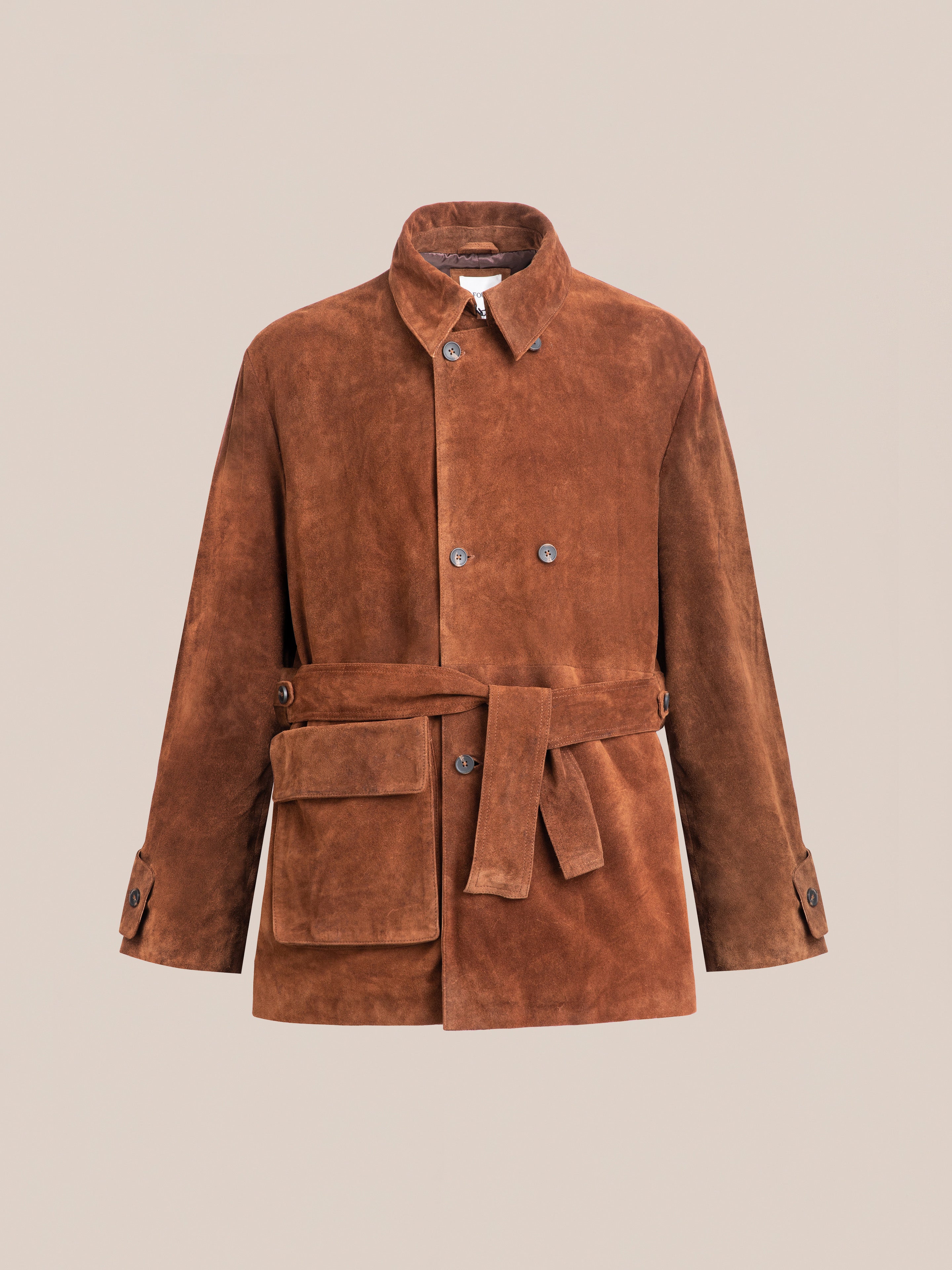 Explore FOUND's versatile unisex Double Breasted Suede Leather Jacket with buttoned cuffs, large front pocket, and belt. This ethically made piece stands out on a beige background.