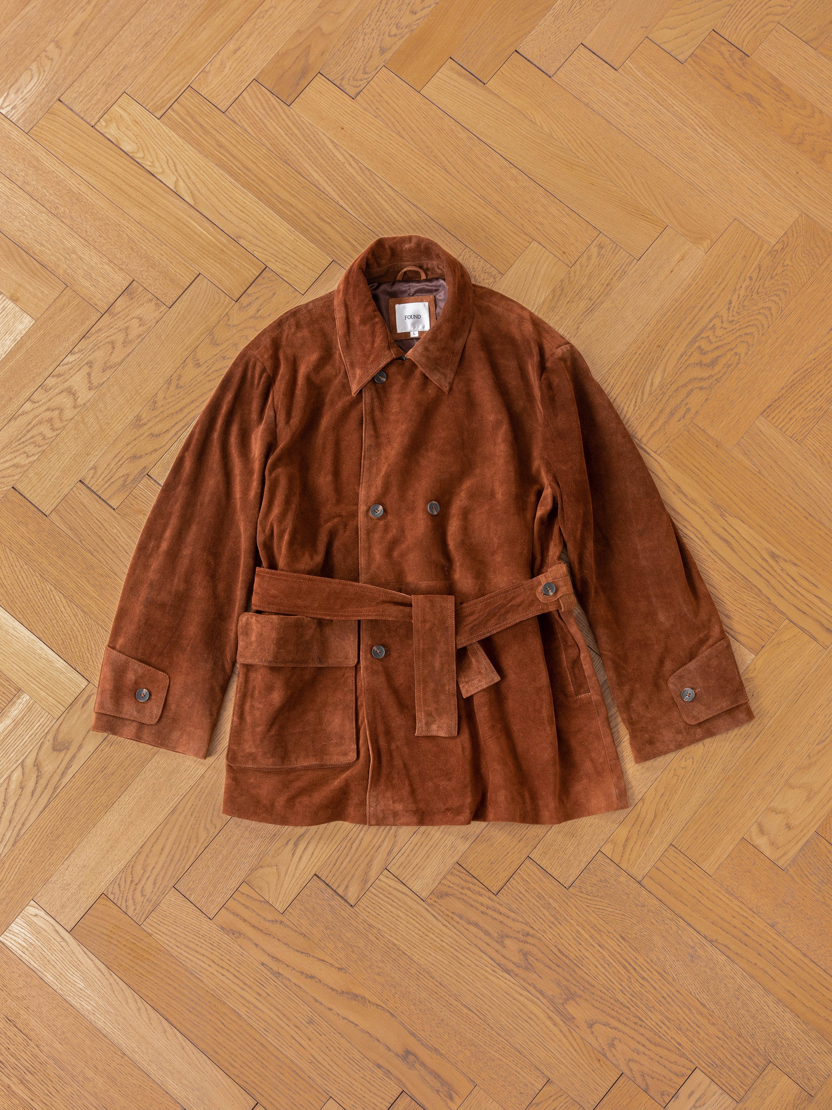 FOUND's ethically produced, unisex Double Breasted Suede Leather Jacket is elegantly displayed on a wooden herringbone-pattern floor.