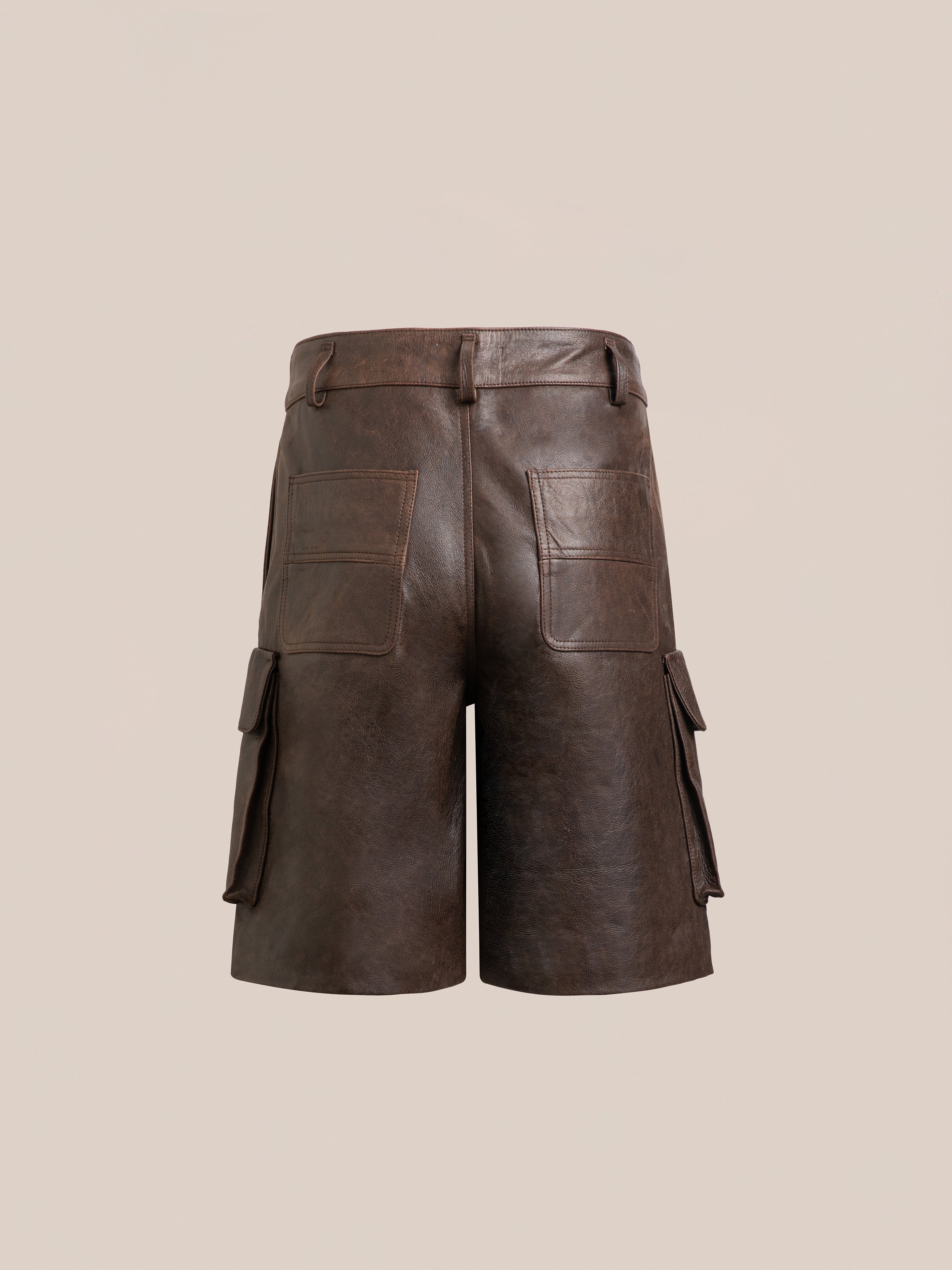 The Dusk Distressed Genuine Leather Cargo Shorts by FOUND feature belt loops, two back pockets, and side cargo pockets. They are crafted from ethically sourced materials and are shown from the back against a plain background.