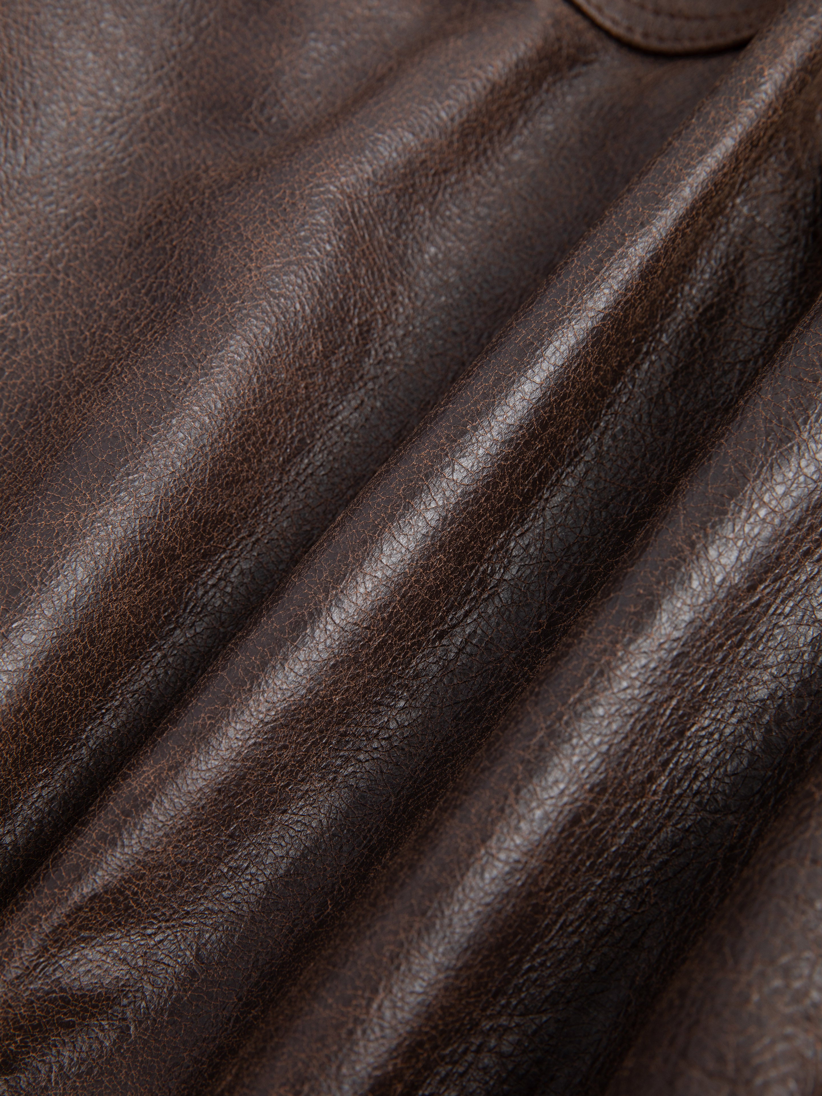 Close-up of ethically sourced brown leather texture and creases from the Dusk Distressed Genuine Leather Cargo Shorts by FOUND.