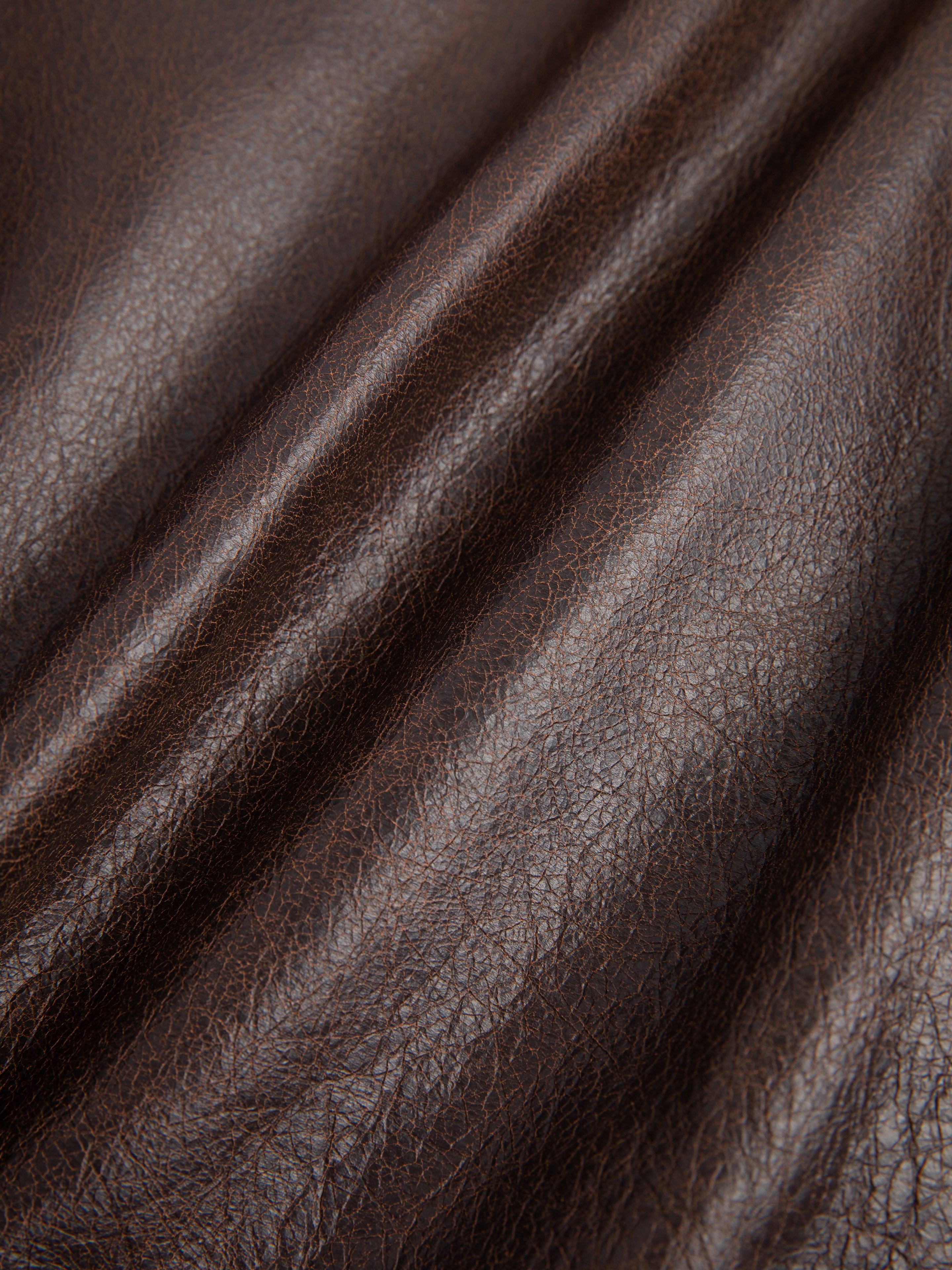 Close-up of the Dusk Distressed Genuine Leather Hoodie by FOUND, highlighting the textured and folded brown cowhide leather that showcases the rich quality of ethically sourced materials.