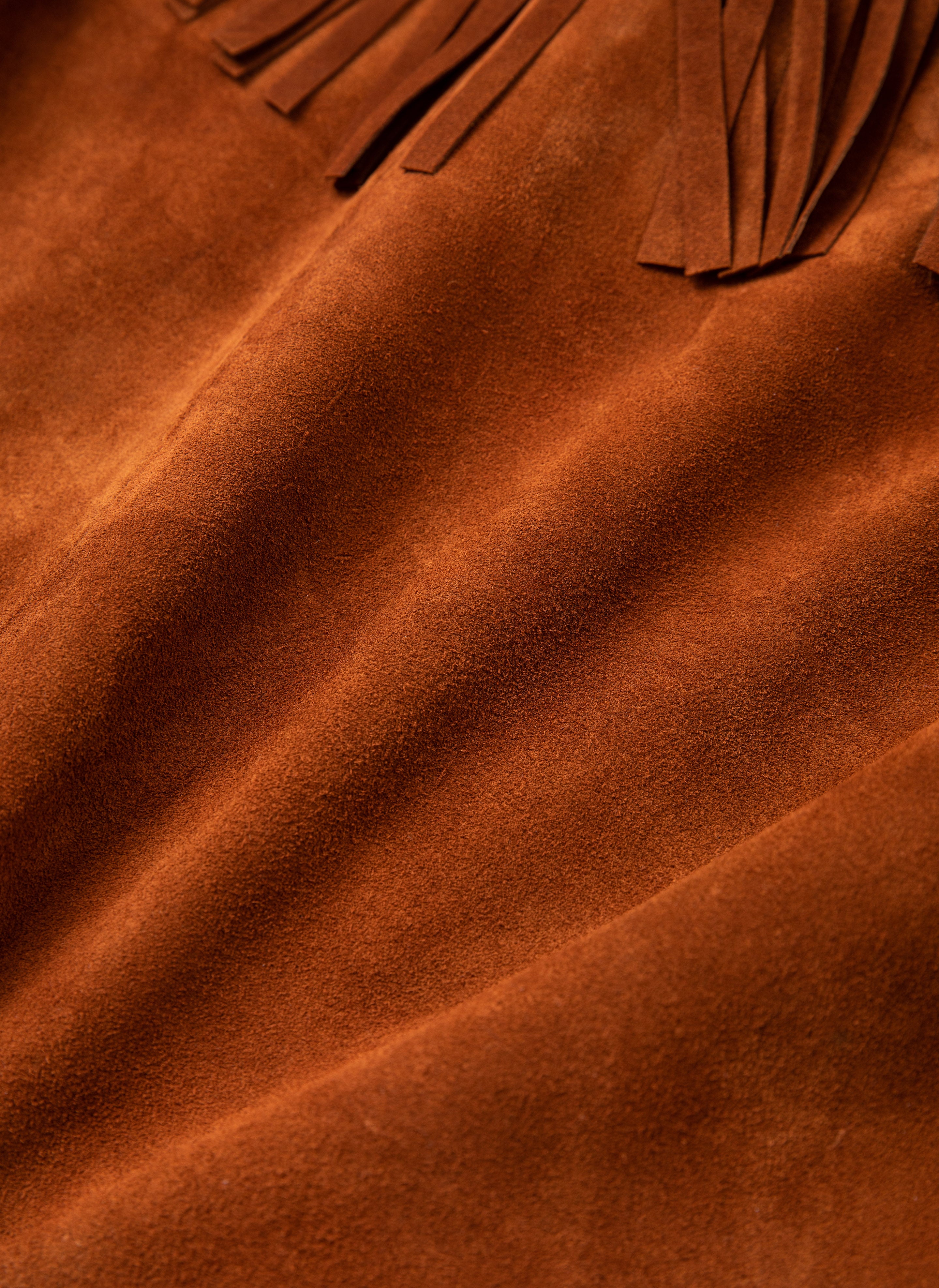 Close-up of FOUND's Western Fringe Suede Leather Jacket, showcasing brown suede fabric with fringed edges and a visible texture, crafted from ethically sourced materials.