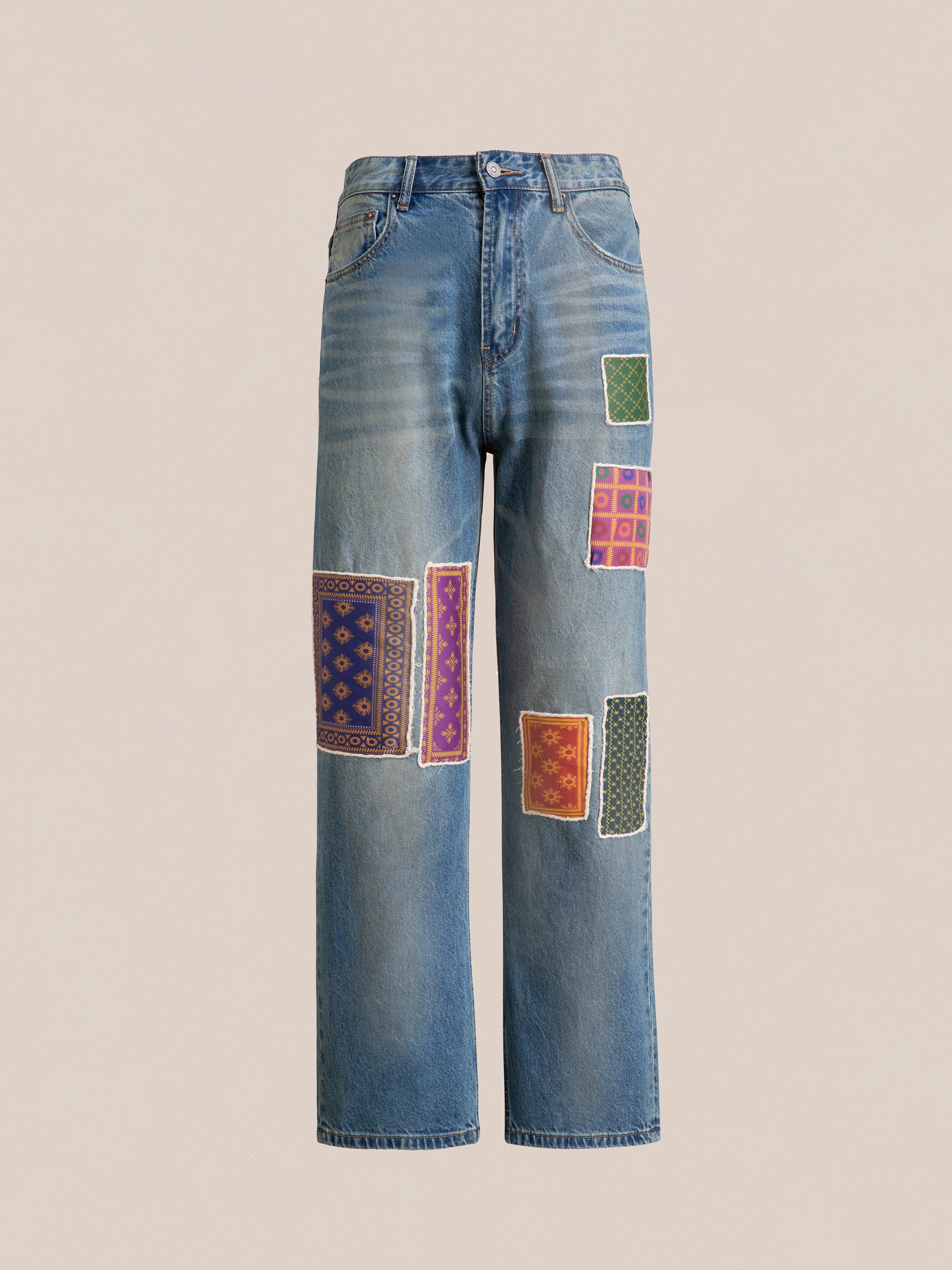 The Kantha Patchwork Jeans by Found are blue denim with a high waist and wide legs, adorned with South Asian inspired patches and colorful Kantha patchwork designs on the front.