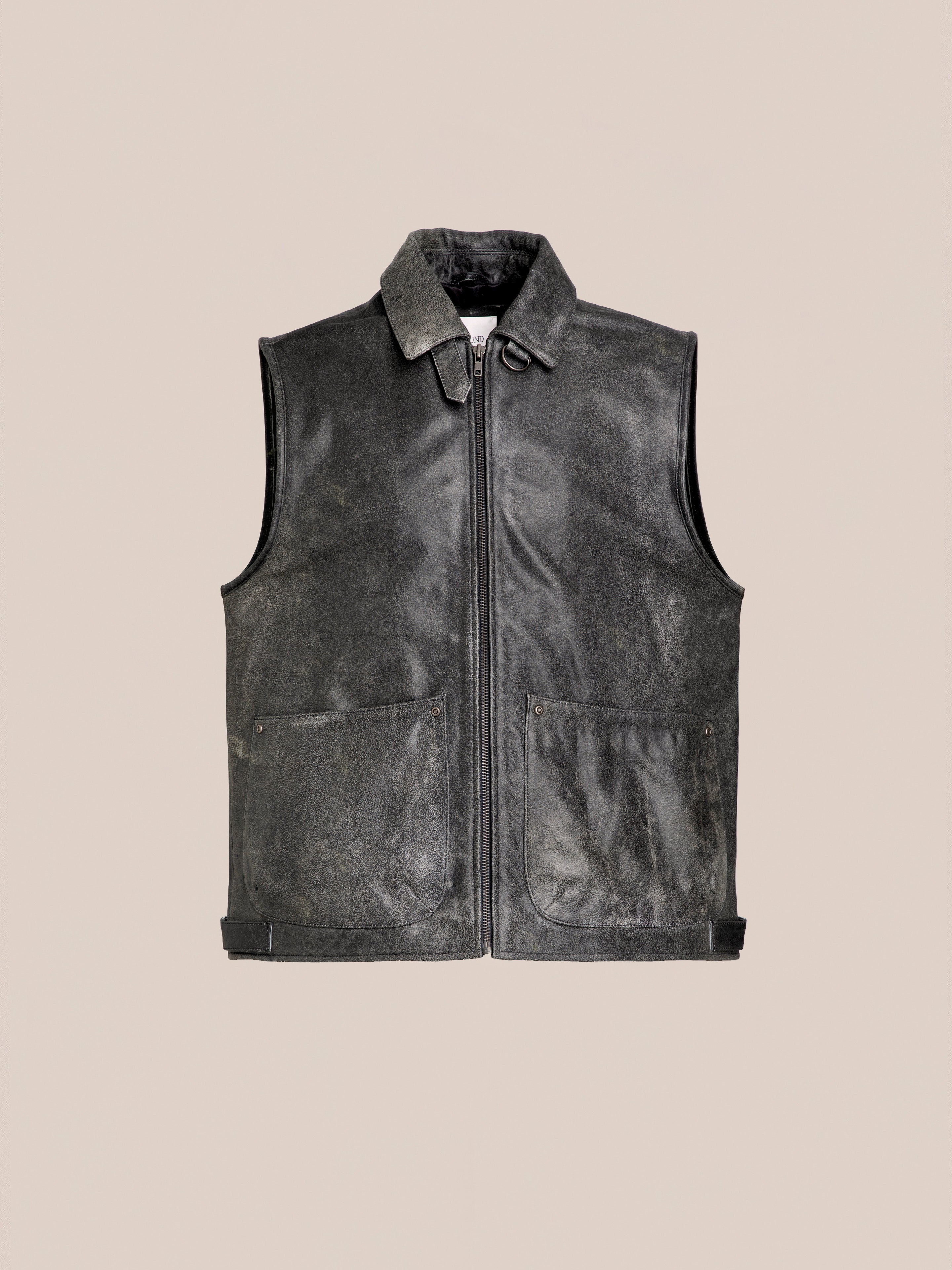 A black Distressed Genuine Leather Pocket Vest by Found, featuring a front zipper, two large front pockets, and a collar, is displayed on a plain beige background. Crafted from ethically sourced materials, this utility vest combines style and sustainability seamlessly.