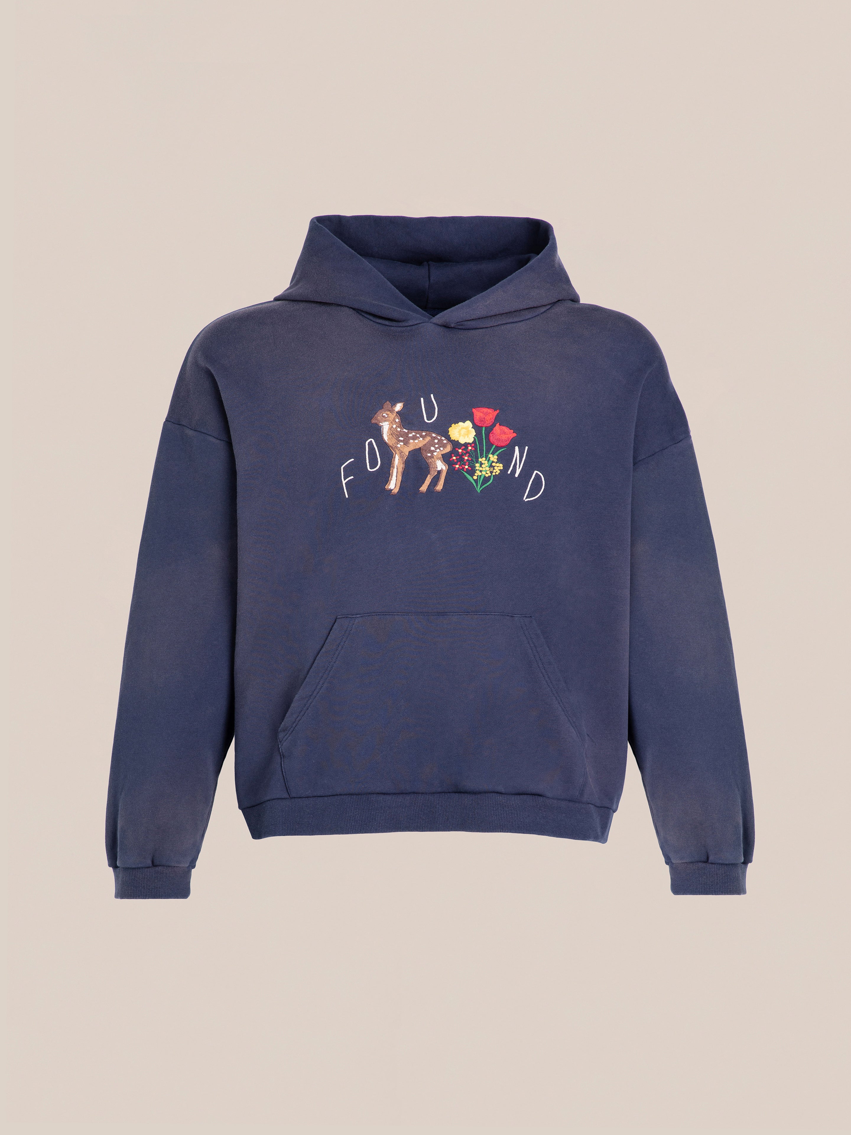 The Floral Embroidered Deer Hoodie by FOUND in navy blue has a floral-deer design and "FOUND" text on the front. Crafted from vintage-washed French terry cotton, it offers a unisex relaxed fit for comfort.