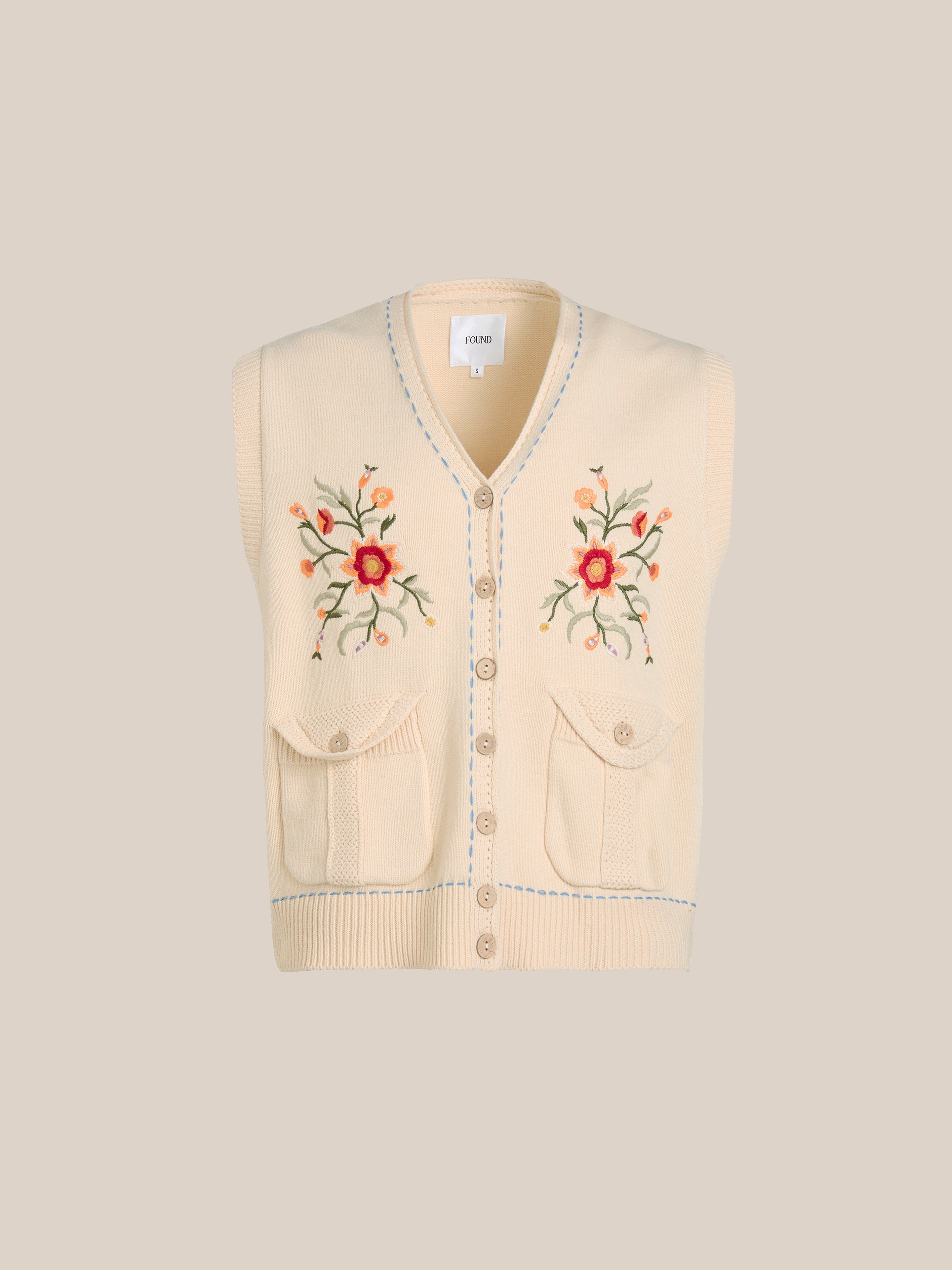 The Floral Embroidered Knit Vest by FOUND offers timeless unisex style with vintage-inspired beige knitting, intricate floral embroidery, a button-down front, and two handy pockets.