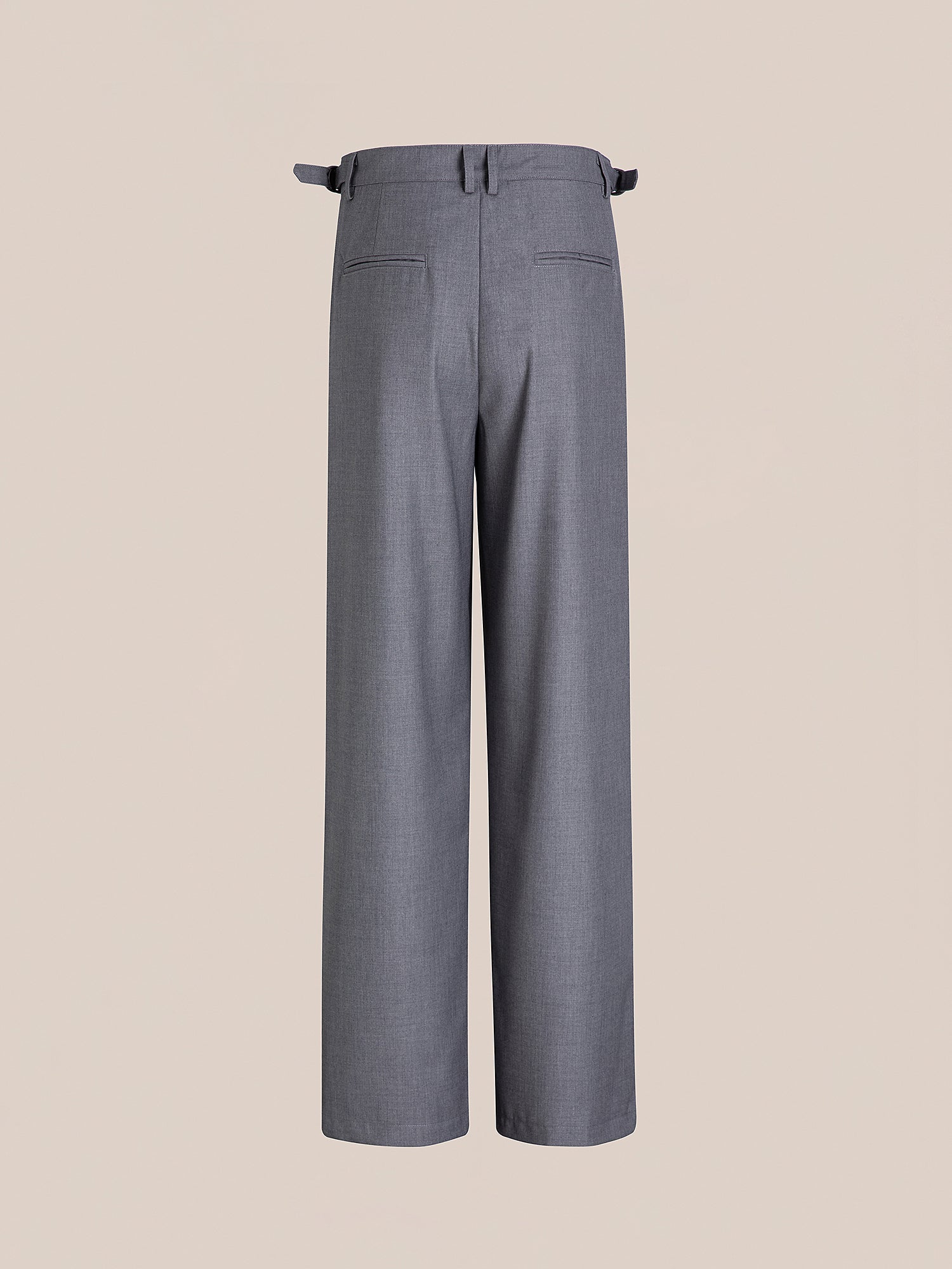 FOUND's Pleated Trousers are high-rise, featuring a wide-leg design with double pleats and adjustable waist tabs, beautifully displayed from the back against a beige backdrop.