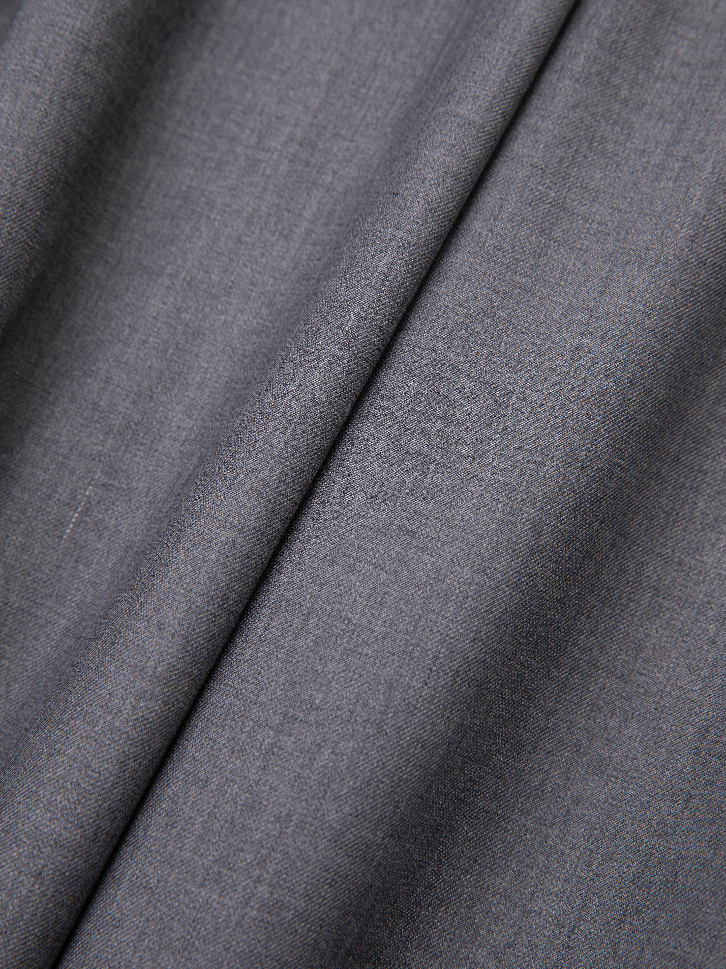 Smooth-textured gray fabric with slight folds, reminiscent of FOUND's high-rise Pleated Trousers.