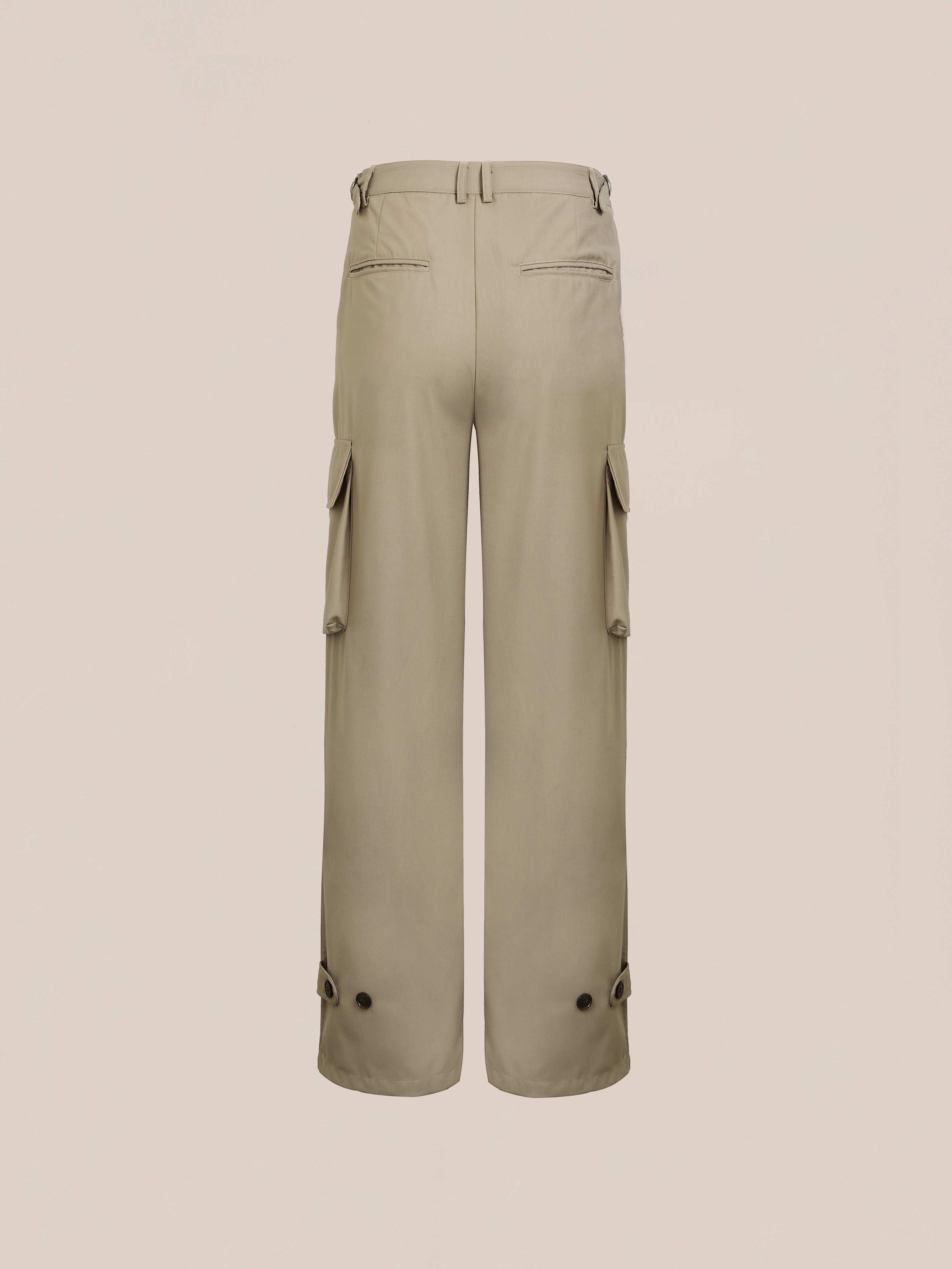 The Hava Pleated Cargo Trousers by FOUND, made of beige cotton twill with side pockets, belt loops, and button-accented cuffs, showcase a utilitarian style when viewed from the back against a plain background.