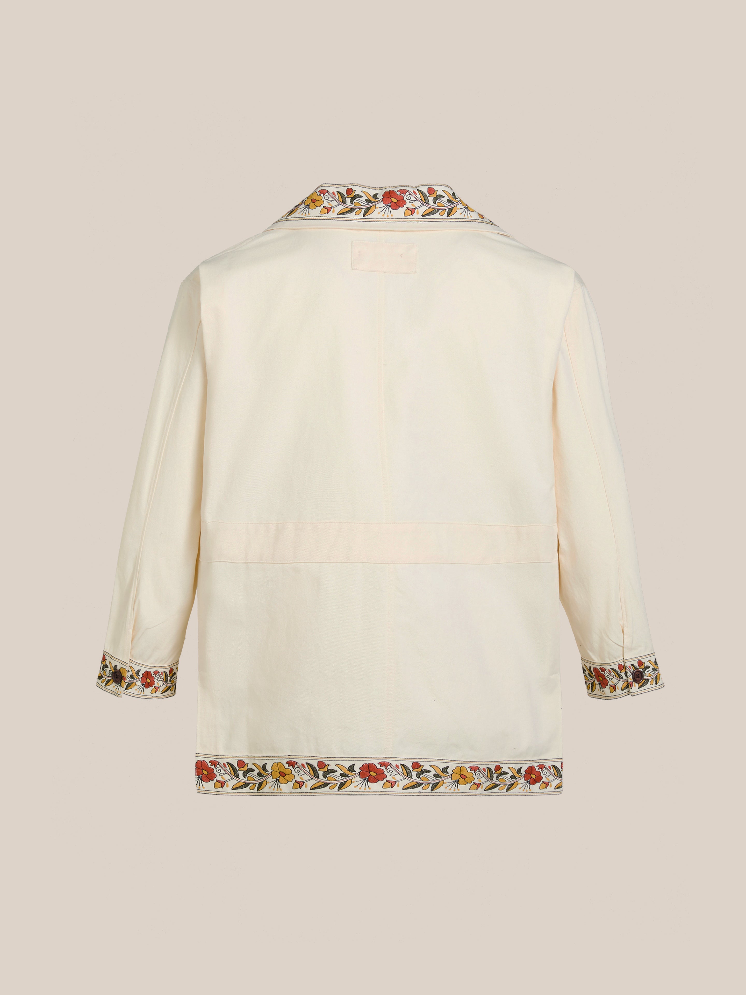 The back view of the Kantha Floral Work Jacket by FOUND highlights its cream color with three-quarter sleeves, featuring exquisite Kantha floral embroidery on the cuffs and hemline for a vintage touch.