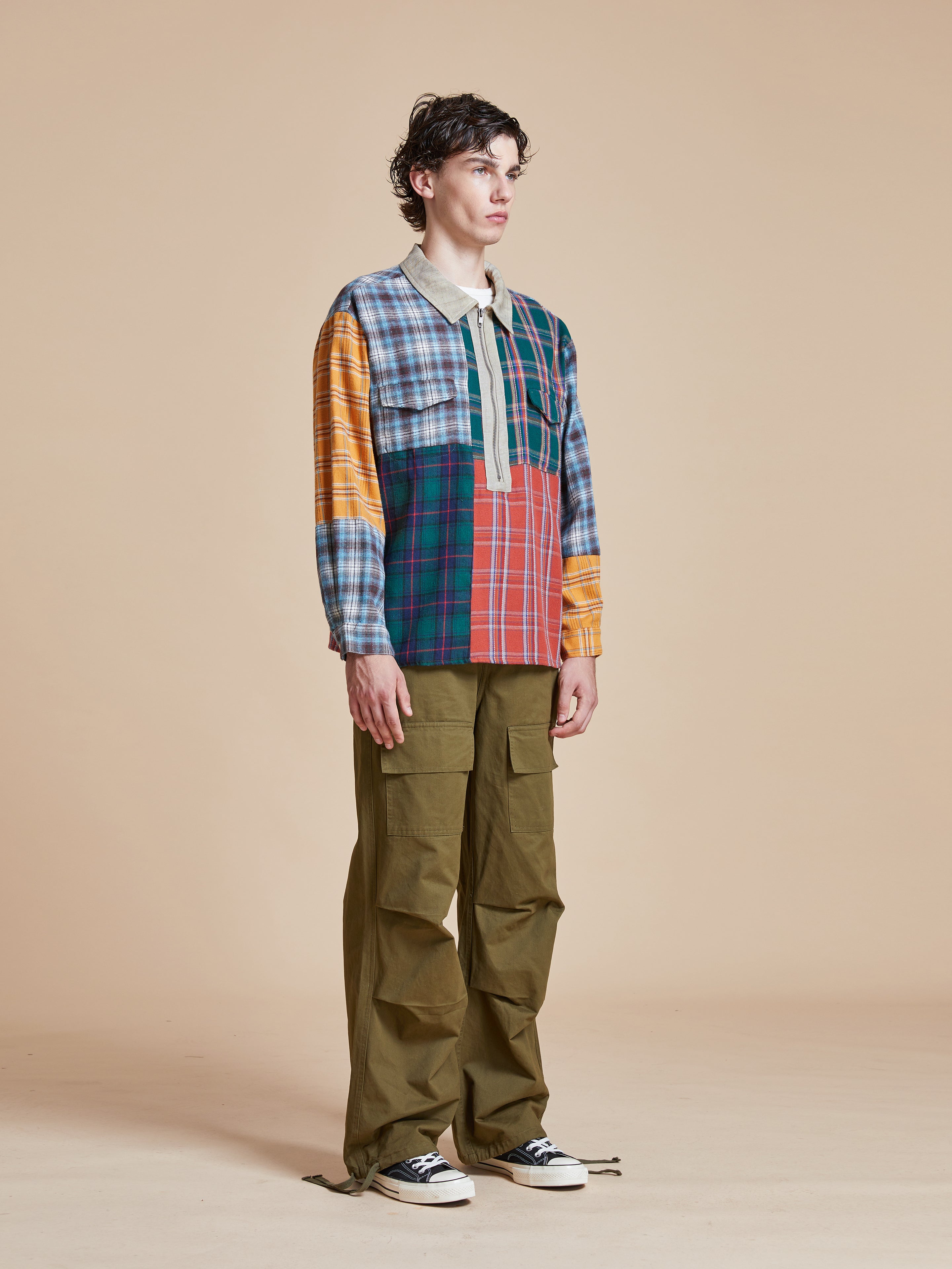 A man wearing a Multi Plaid Tartan Shirt by Found and pants.