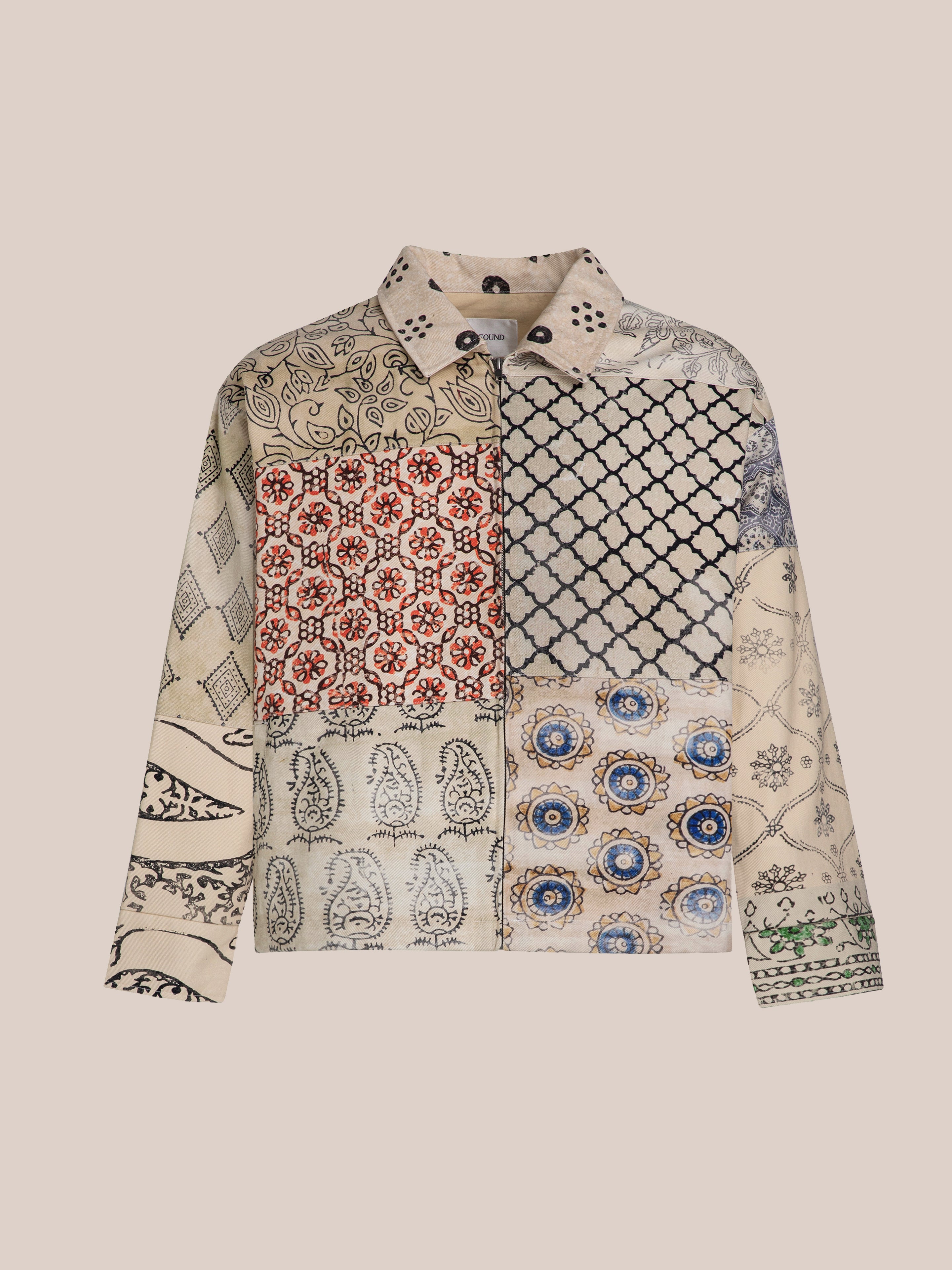 The FOUND Paisley Mosaic Work Jacket is unisex and features a patchwork design with paisley mosaic, floral, and geometric patterns in beige, red, black, and blue on a light background.