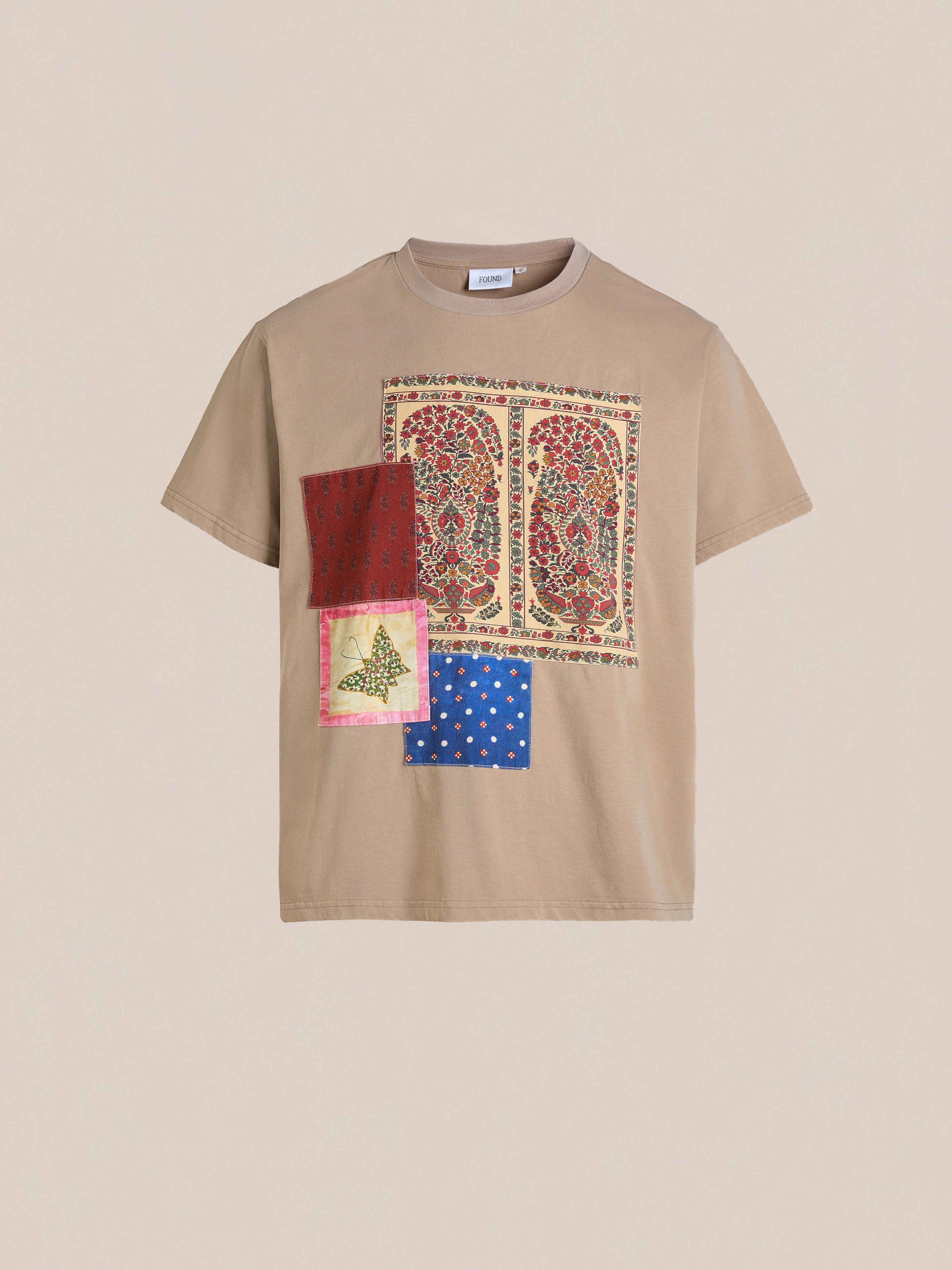 FOUND's Patchwork Tee is a tan top showcasing three vibrant designs like floral and butterfly, embellished with Kantha style embroidery for a unique touch.