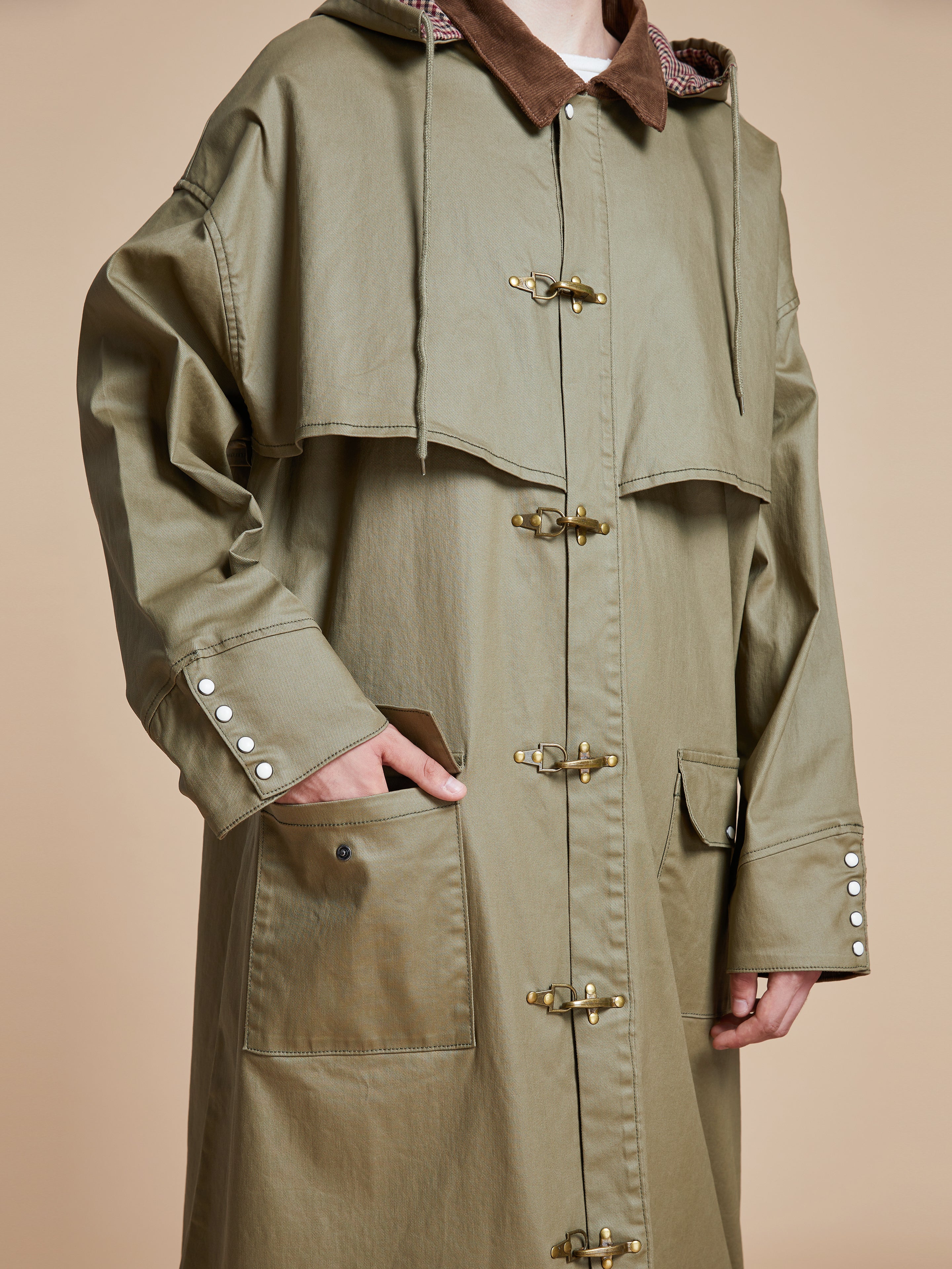 A man wearing a green Found Prairie Buckle Coat.