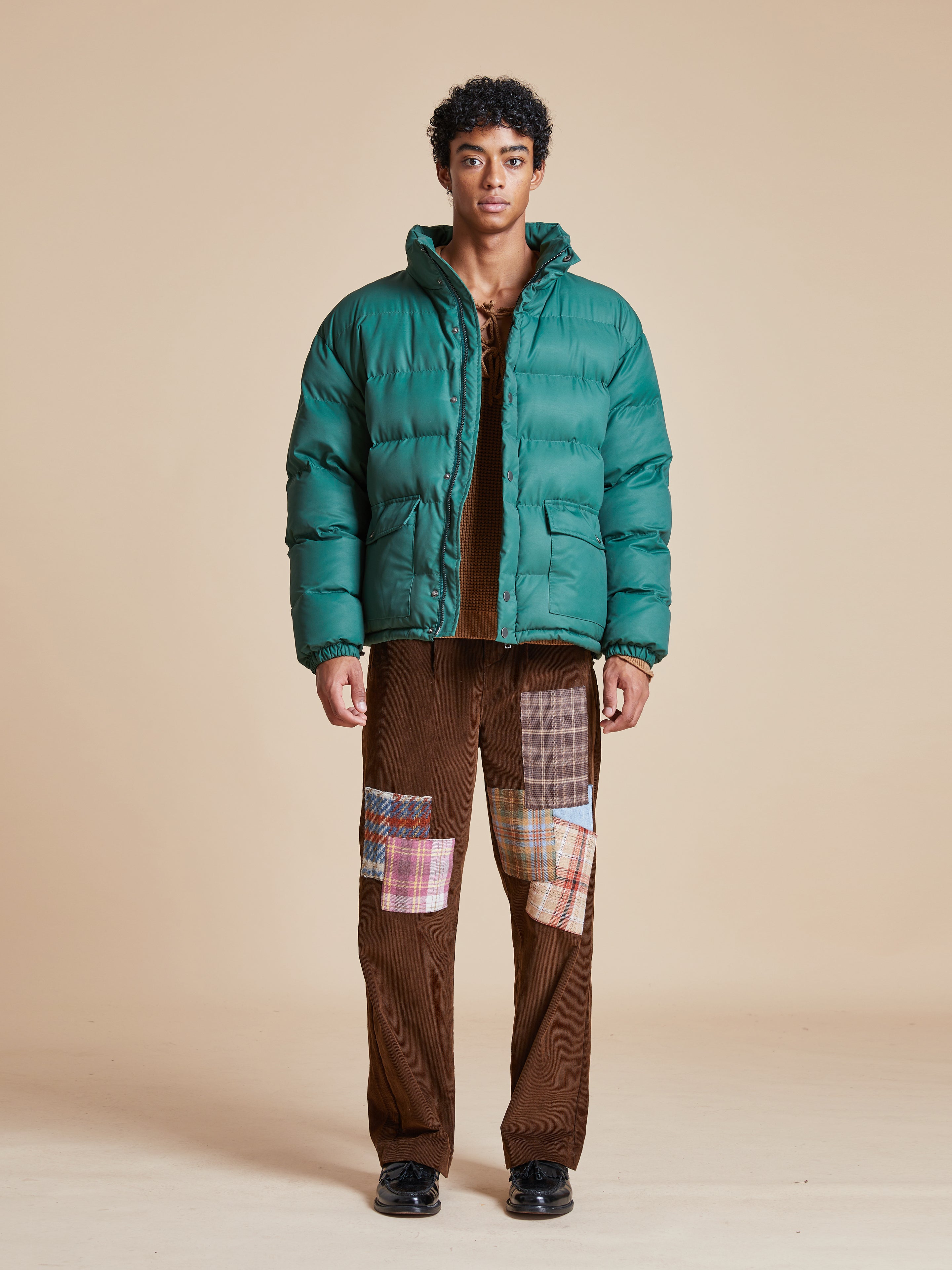 A man wearing a deep green Found Laurel Pine Puffer Jacket.