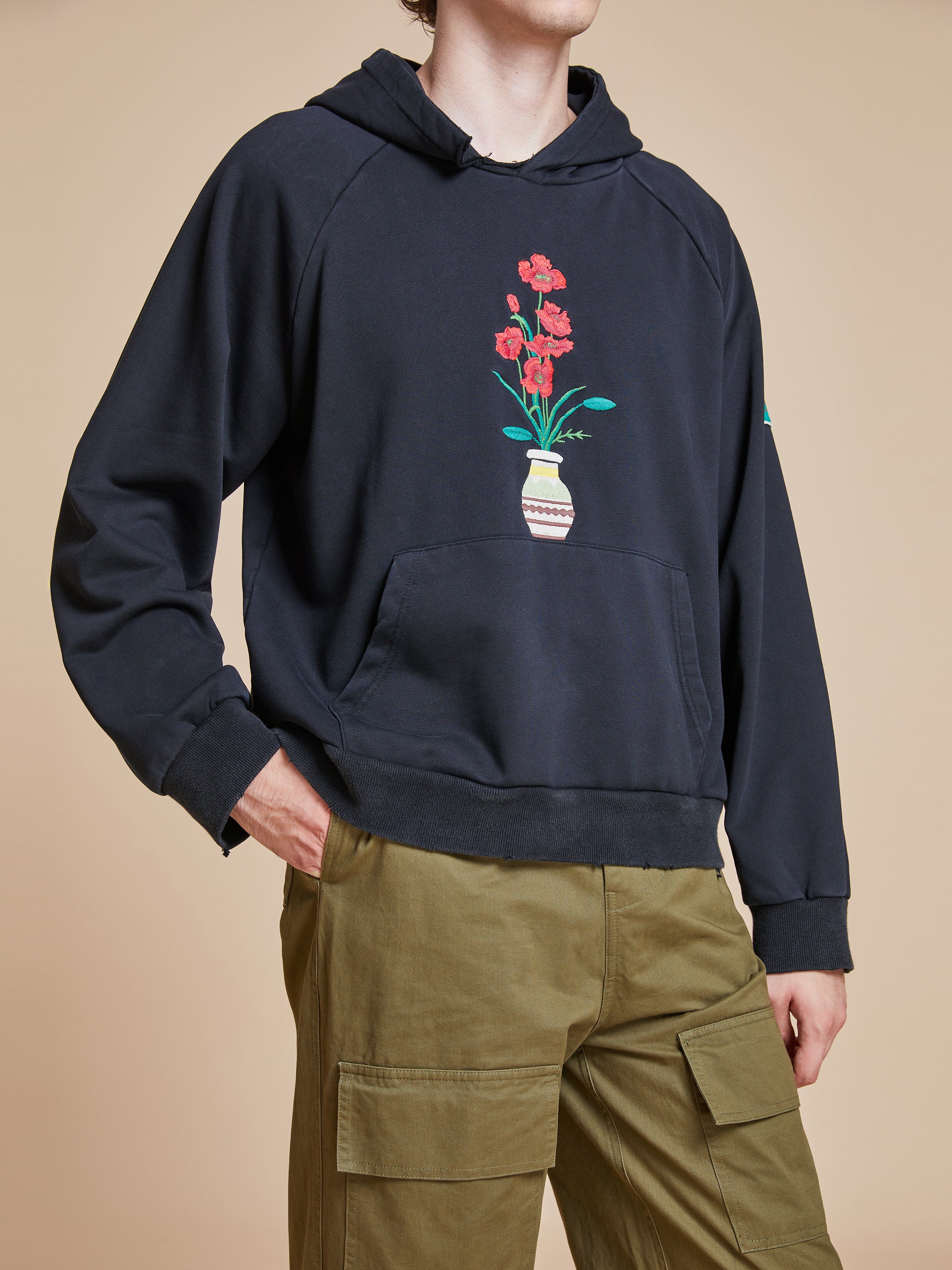 A man wearing a Found Flowers Vase Hoodie.