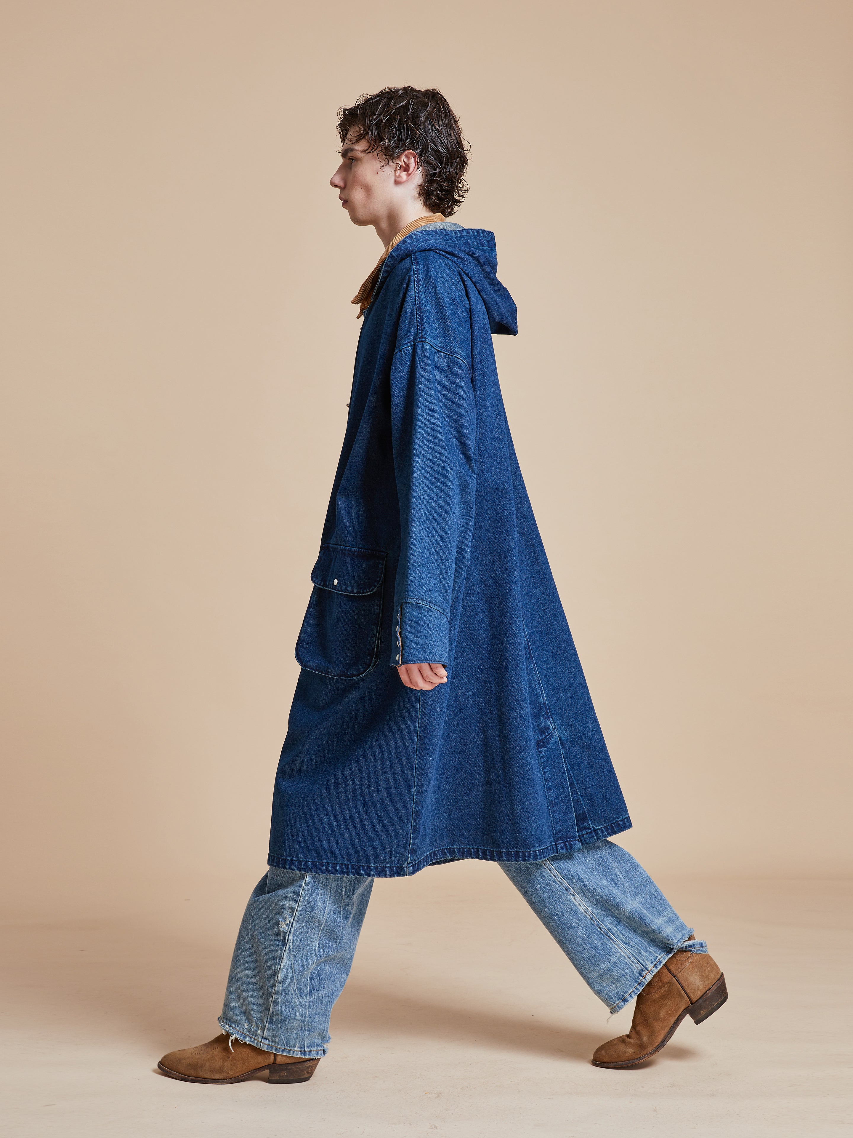 A man in a Found Sargasso Denim Buckle Coat walking.