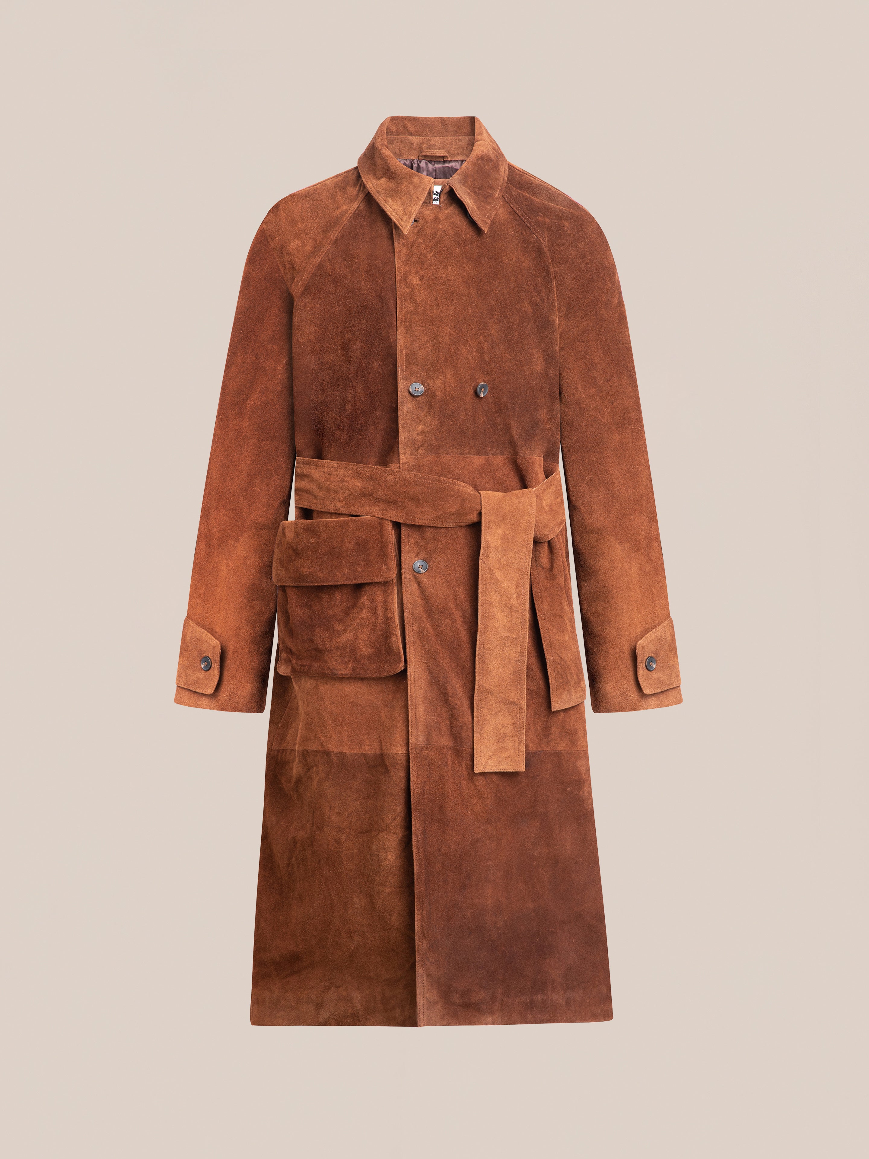 FOUND's Suede Leather Trench Coat, ethically crafted in brown suede, features a tie belt and front pocket, elegantly showcased against a plain backdrop.