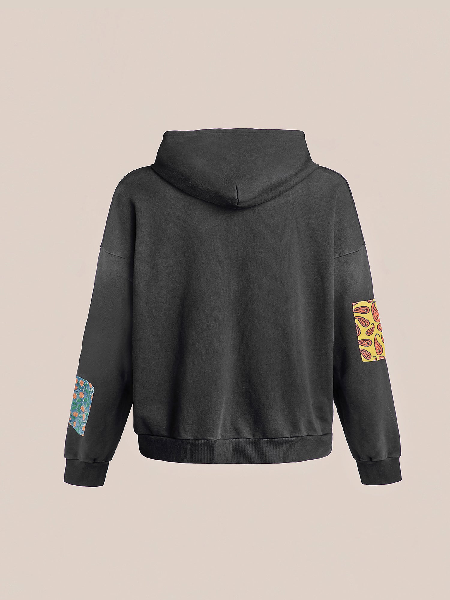 The Tapestry Patchwork Zip Up Hoodie from FOUND is a black garment crafted from French terry cotton, adorned with vibrant vintage patches on the elbows and one shoulder, all set against a neutral background.