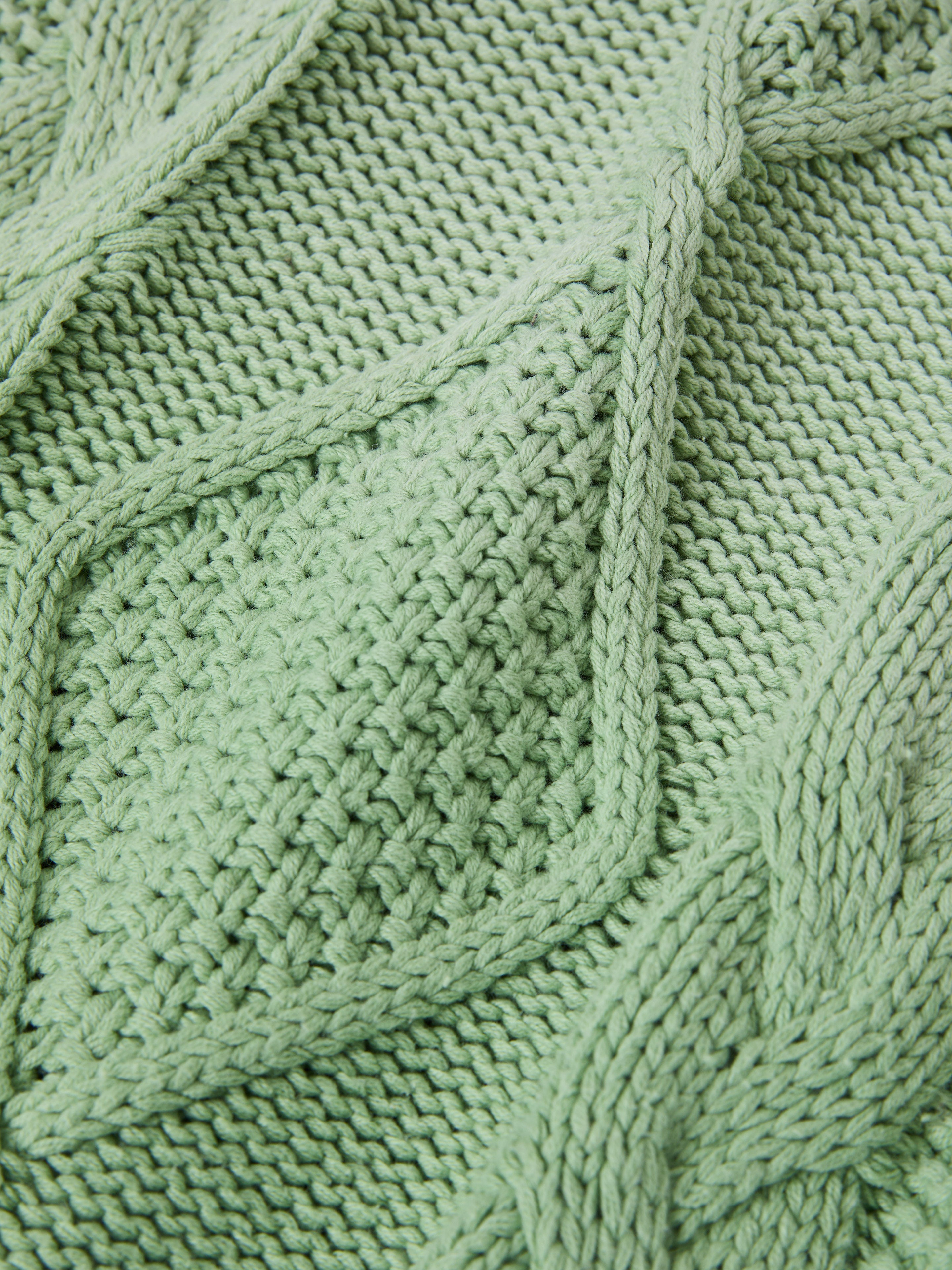 Close-up of a green FOUND Zip Up Cable Knit Hoodie, showcasing an intricate diamond cable knit pattern, designed in a relaxed fit from a cotton blend.