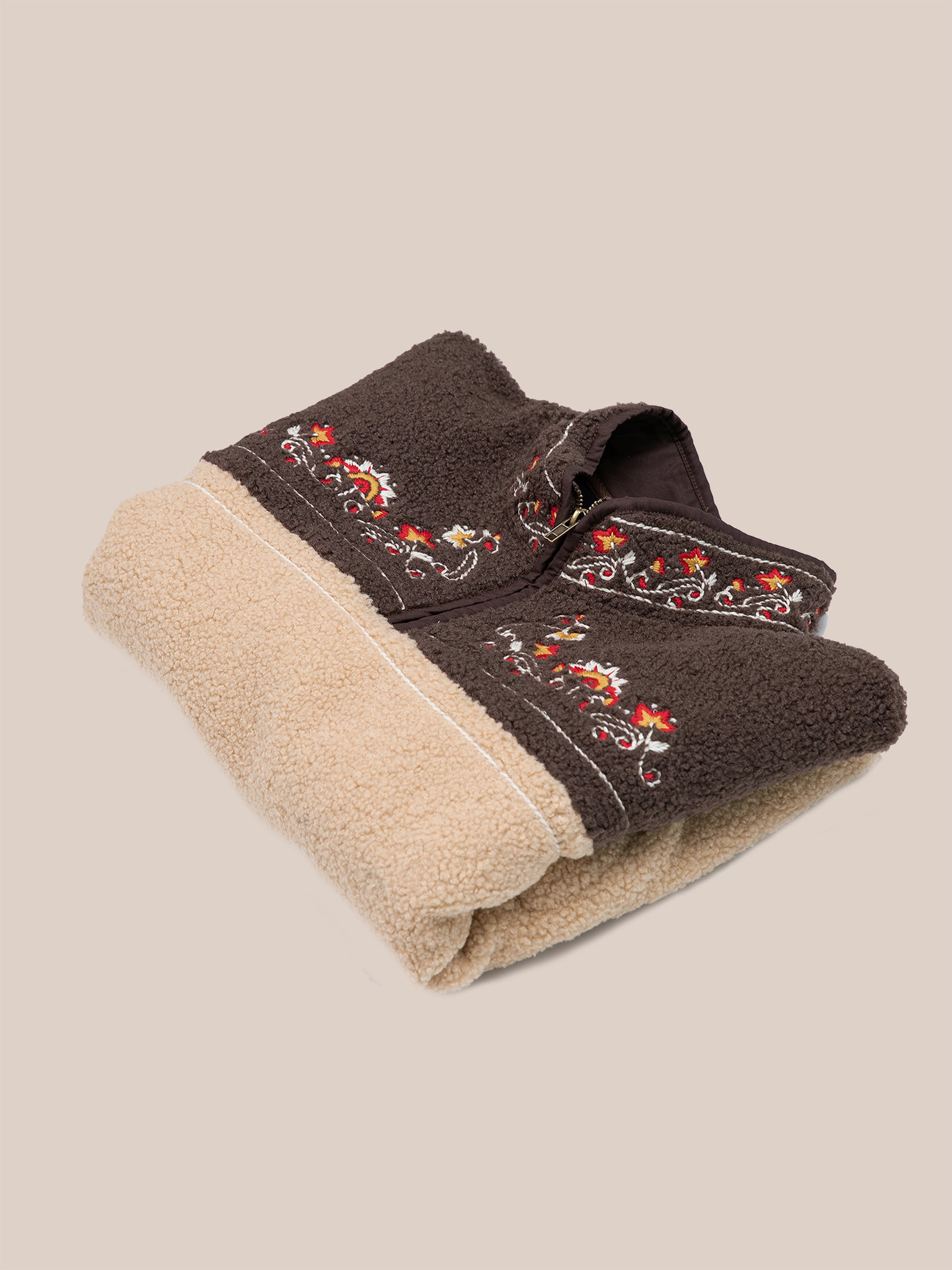 Beige and brown plush towel featuring red and yellow Pahari floral embroidery, inspired by FOUND's Pahari Floral Embroidered Sherpa Pullover.