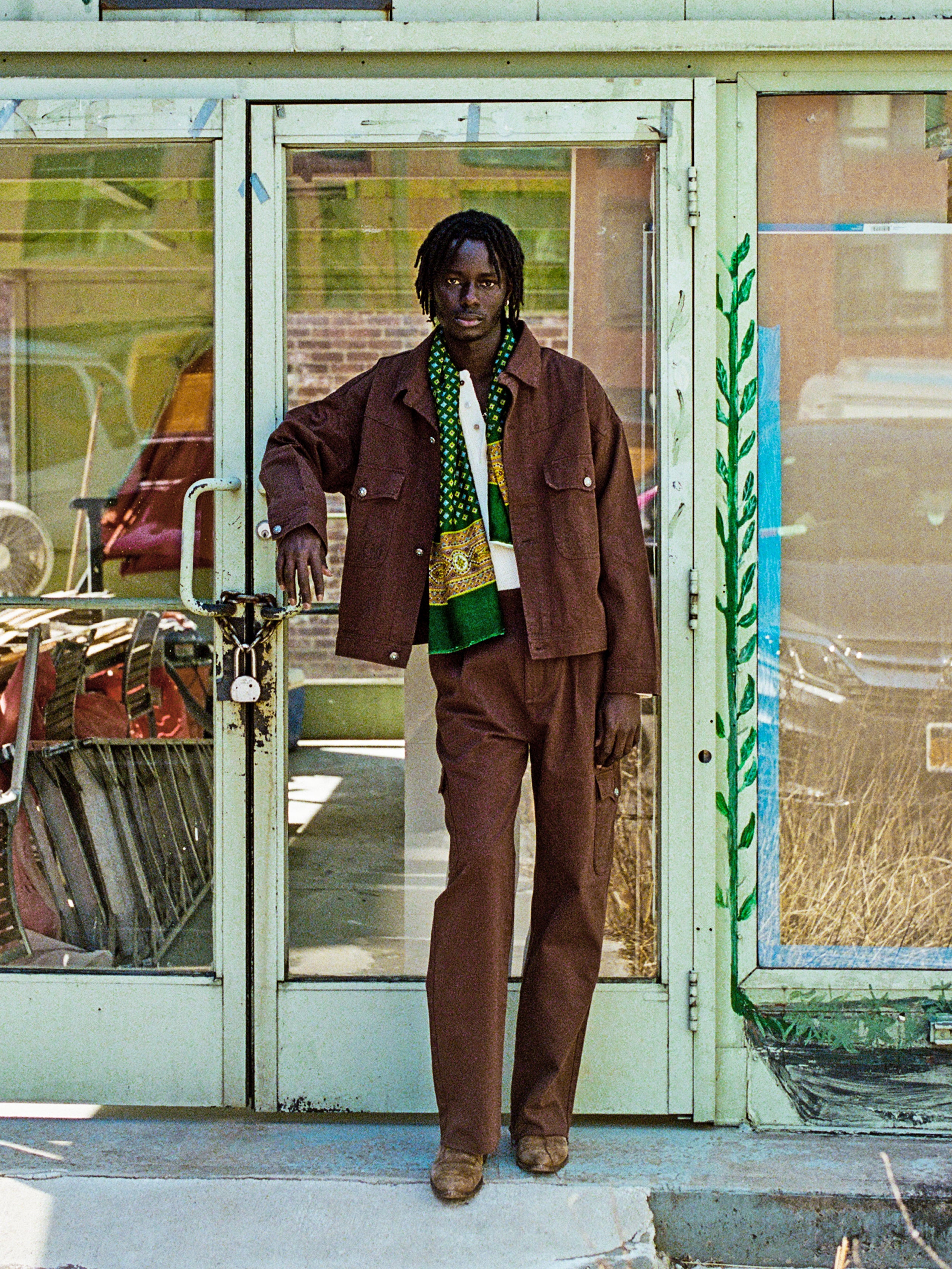 A man wearing a Found Dusky Western Trucker Jacket is standing in front of a store.