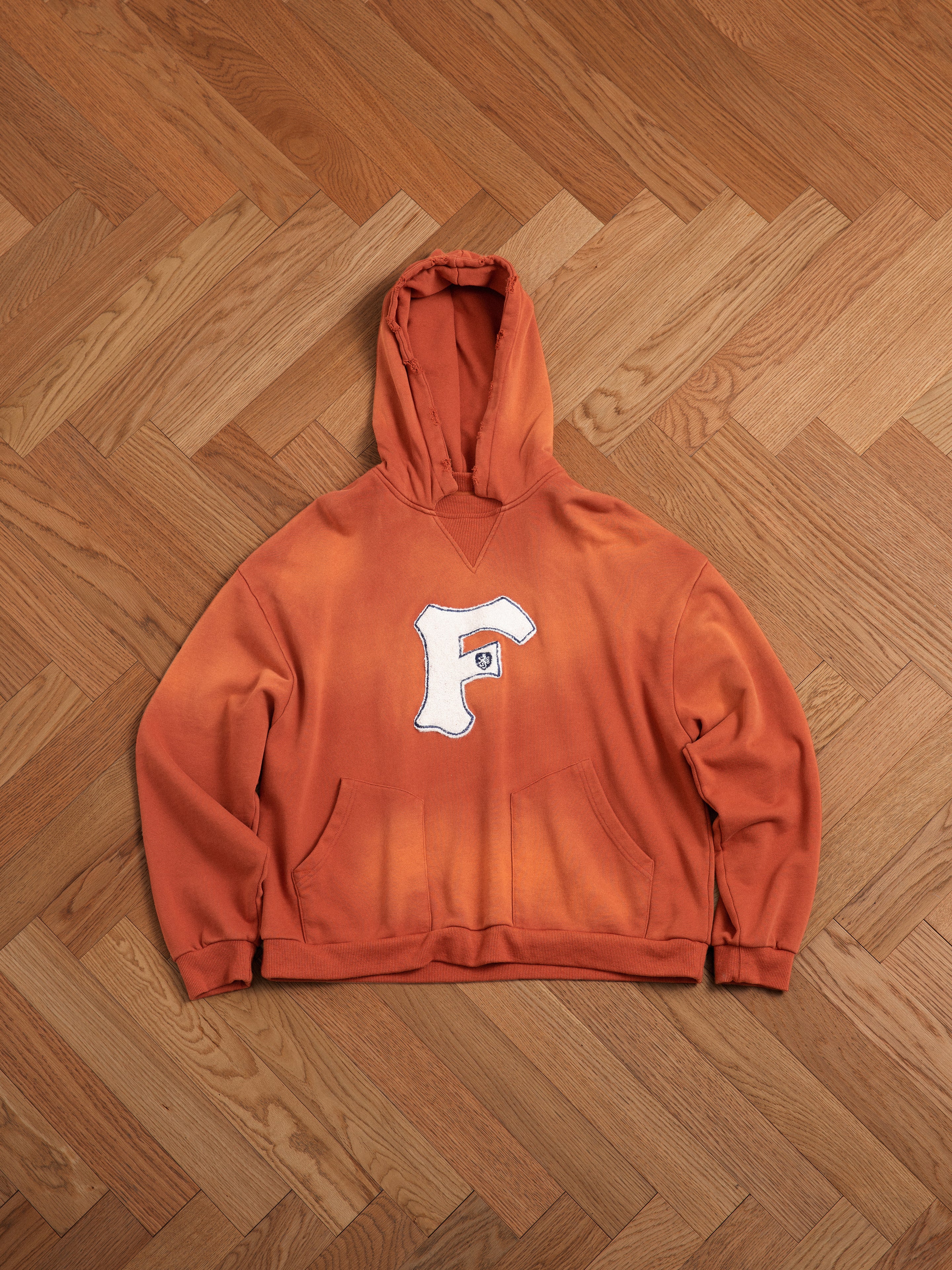 A Found faded "F" hoodie in enzyme washed cotton, evoking vintage nostalgia.