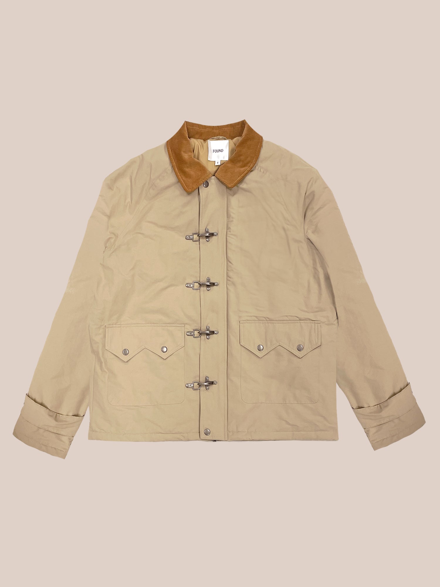 FOUND's Fisherman Jacket features a tan color with a brown collar, buttoned front closure, and two front pockets. Made from a durable cotton blend, it is showcased on a neutral background.