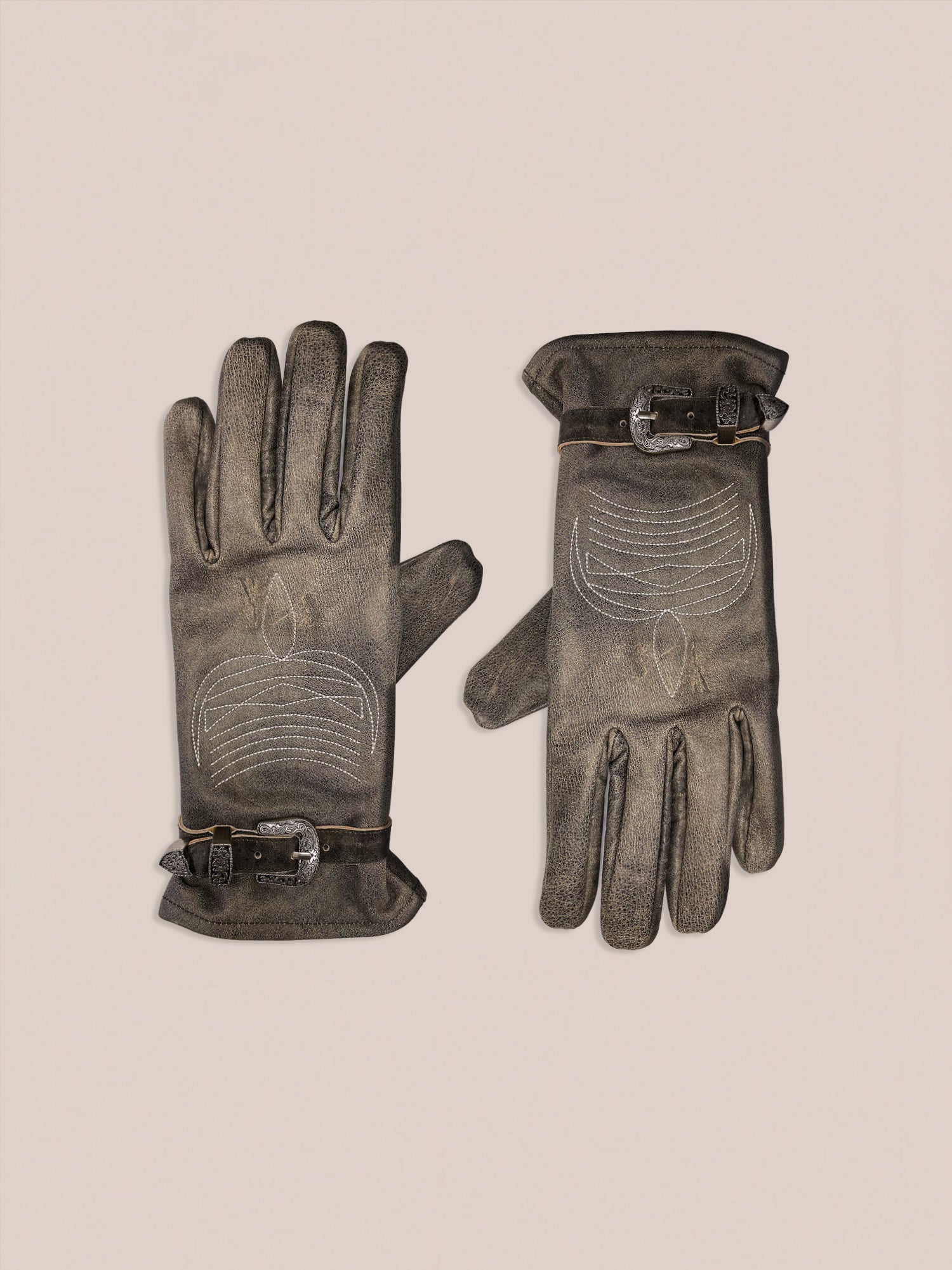 The Distressed Leather Western Gloves by FOUND, featuring decorative stitching and buckle details in brown leather, are displayed on a light background.