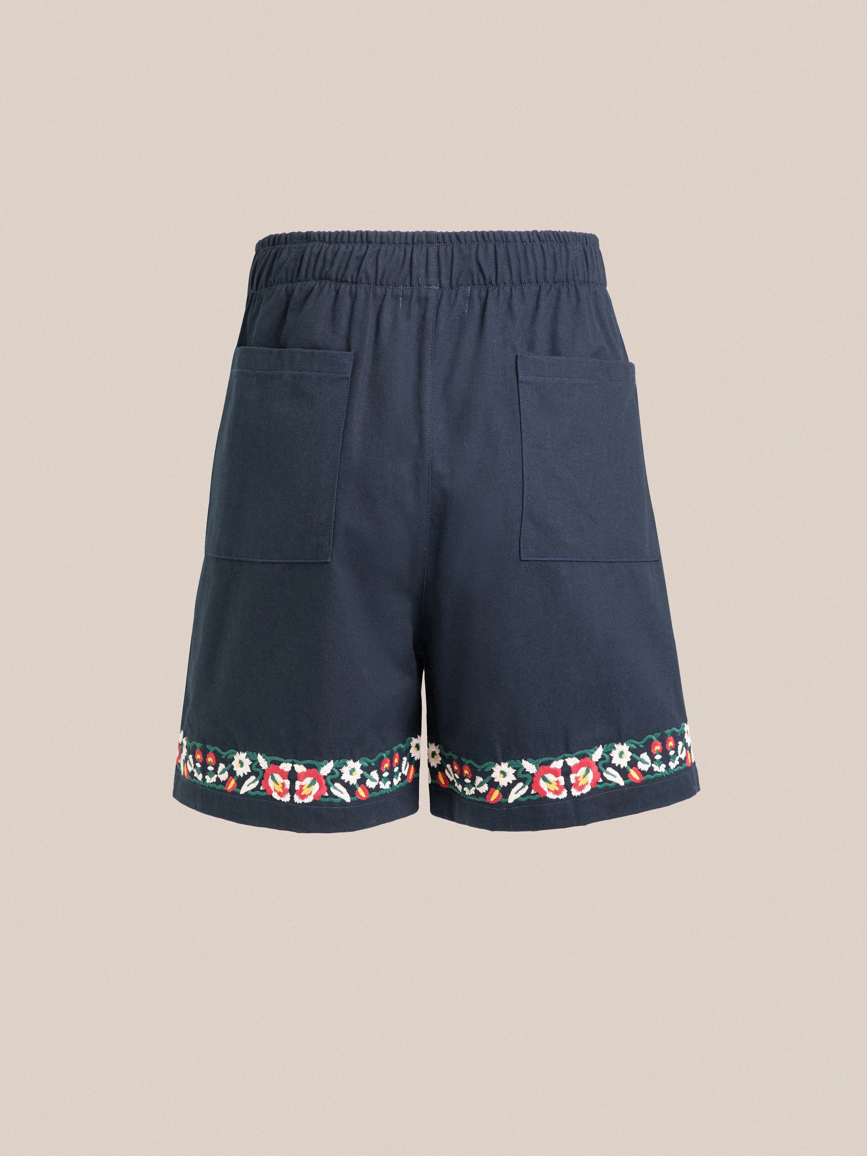 Navy blue Horse Equine Twill Shorts with floral embroidery along the hem, featuring elastic waistband and large front pockets, displayed against a neutral background by Found.