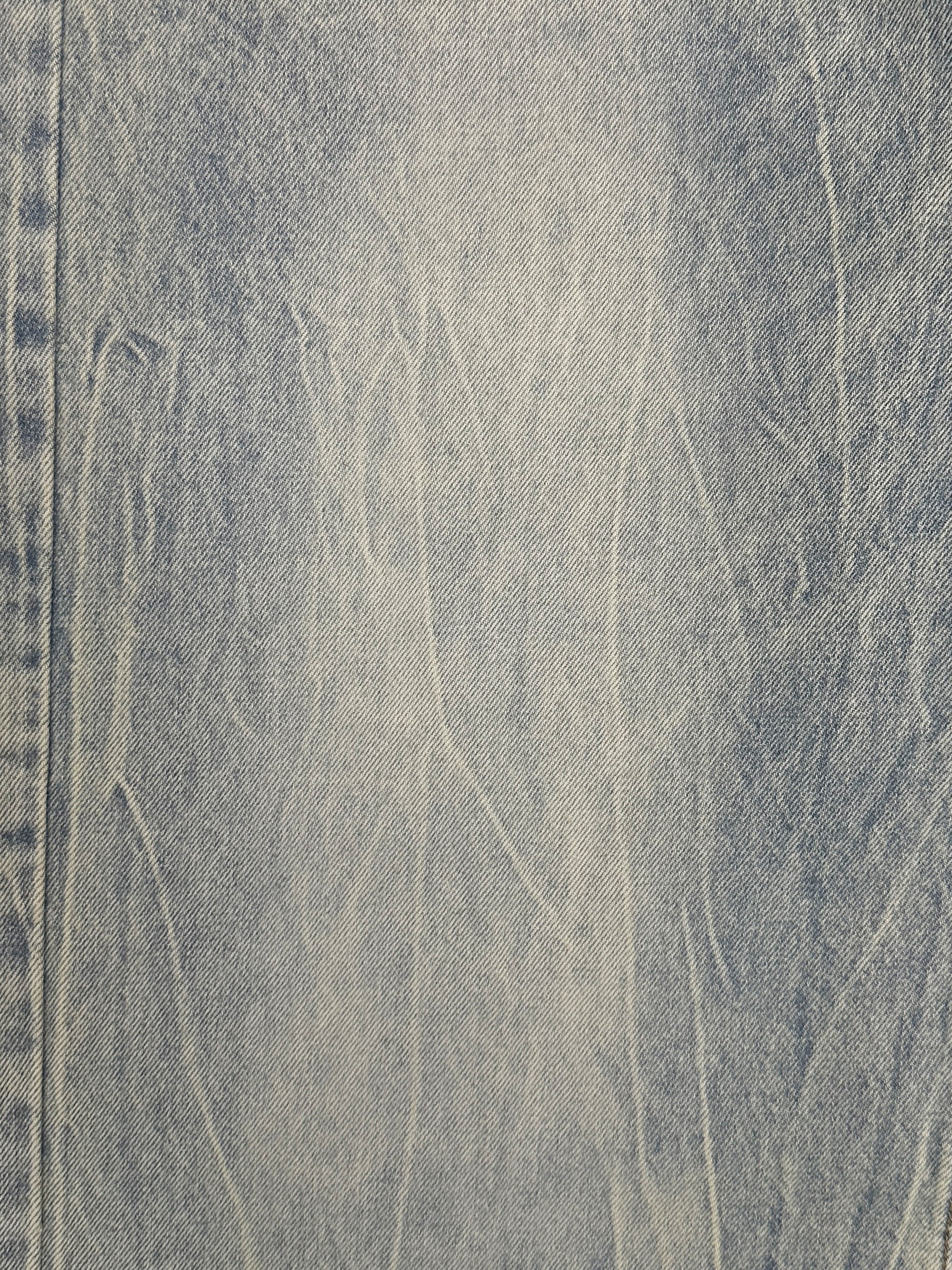 A close-up of the light blue denim fabric from Found's Lacy Baggy Jeans, showcasing visible creases and stitch detail on the left side.