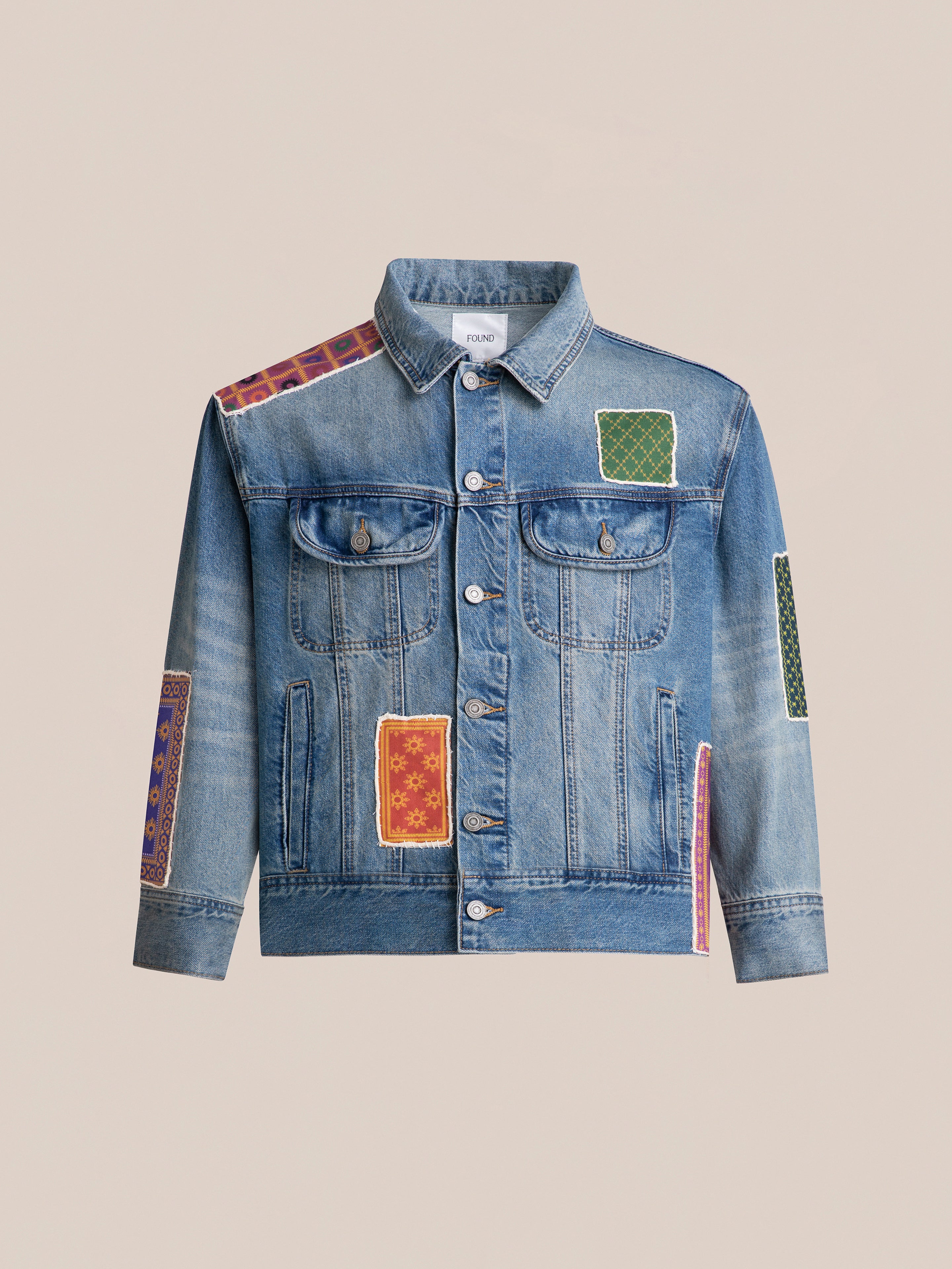 Introducing the FOUND Kantha Patchwork Denim Trucker Jacket, featuring front buttons, double chest pockets, and vibrant Kantha patchwork designs adorning the front, sleeves, and shoulders.