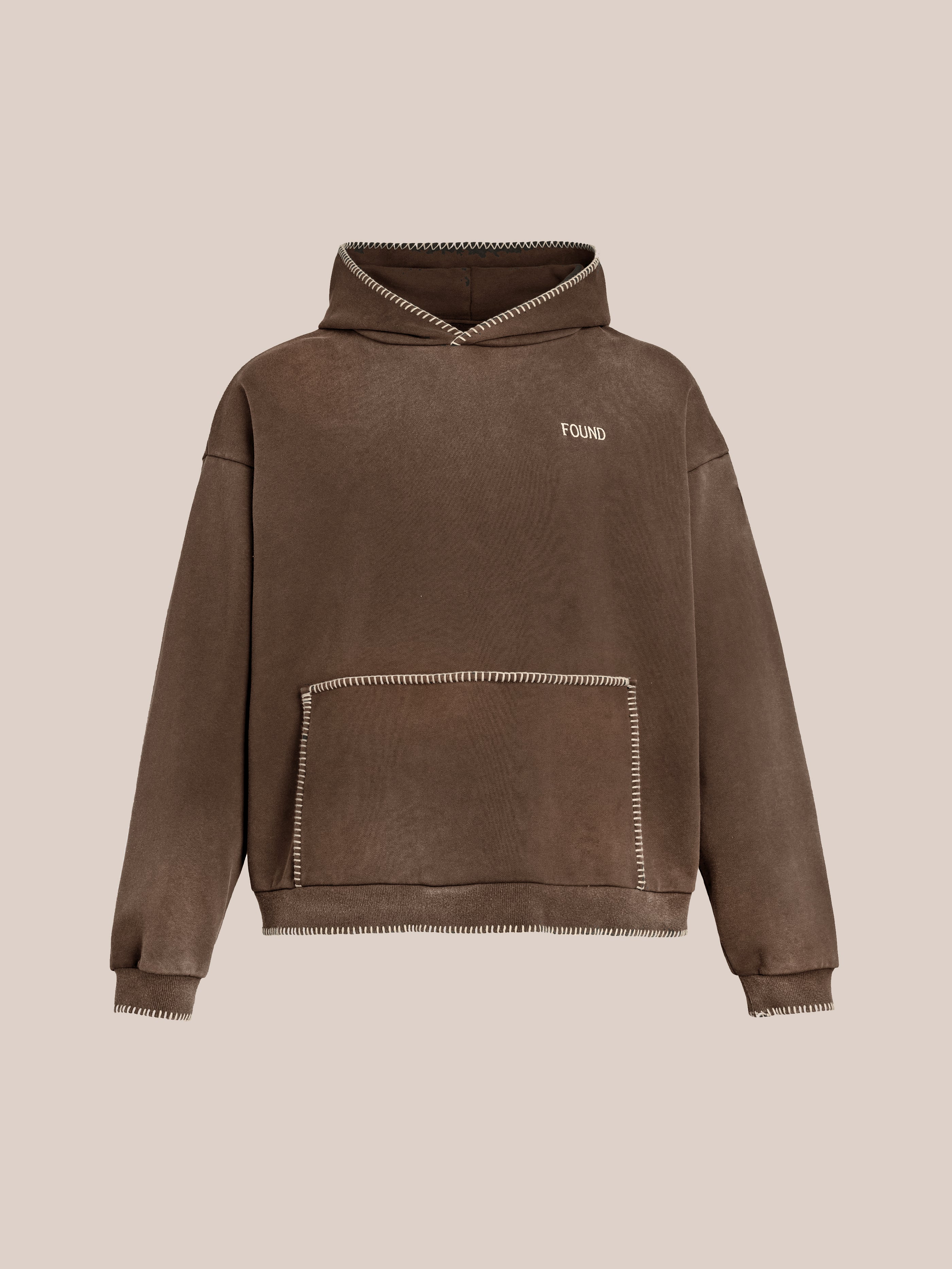 Brown hooded sweatshirt made from French terry cotton with a vintage look, featuring white stitched hem details and a front pocket. The Stitched Border Distressed Logo Hoodie design prominently displays the word "FOUND" on the chest.